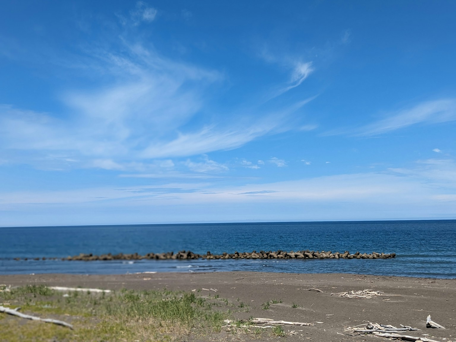 海滩场景，蓝天和海洋，沿海岸排列的岩石