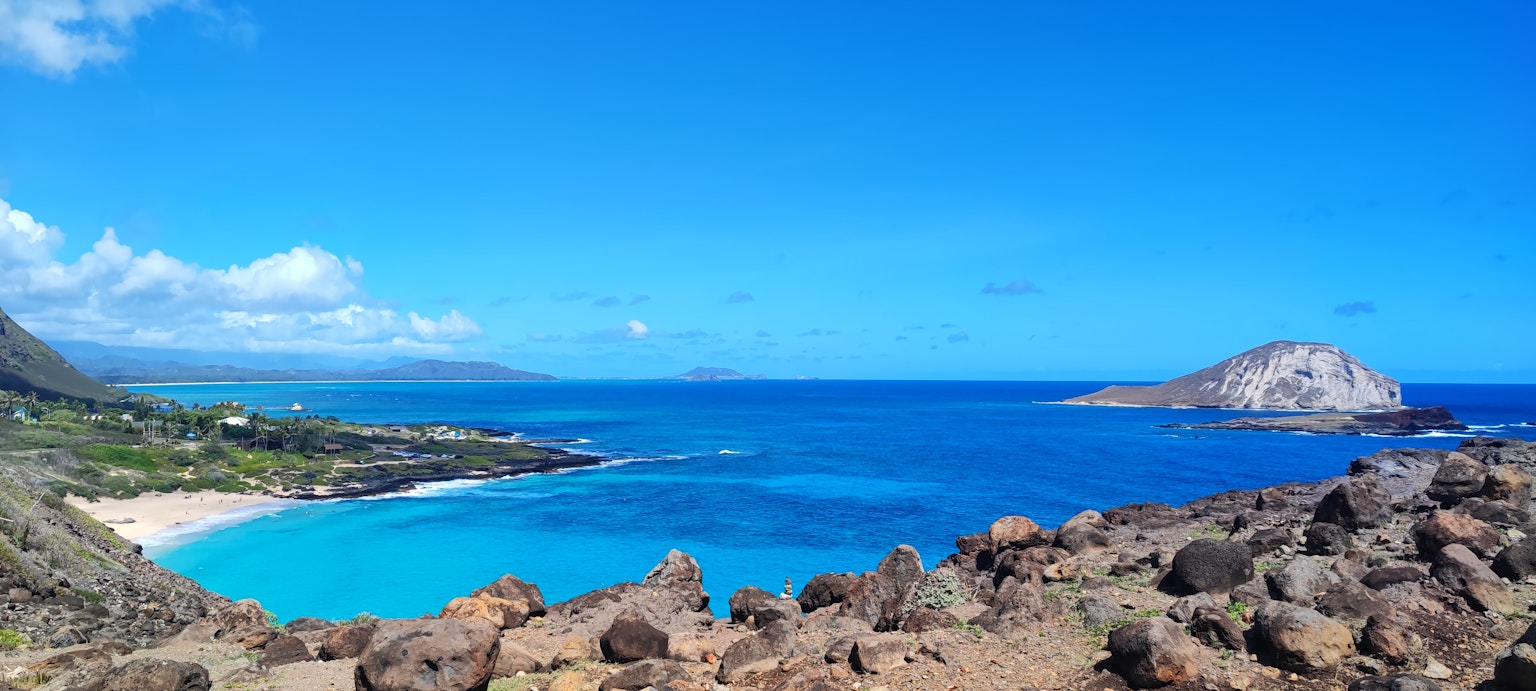 Vue panoramique d'un océan bleu et d'un ciel avec des rochers et une île