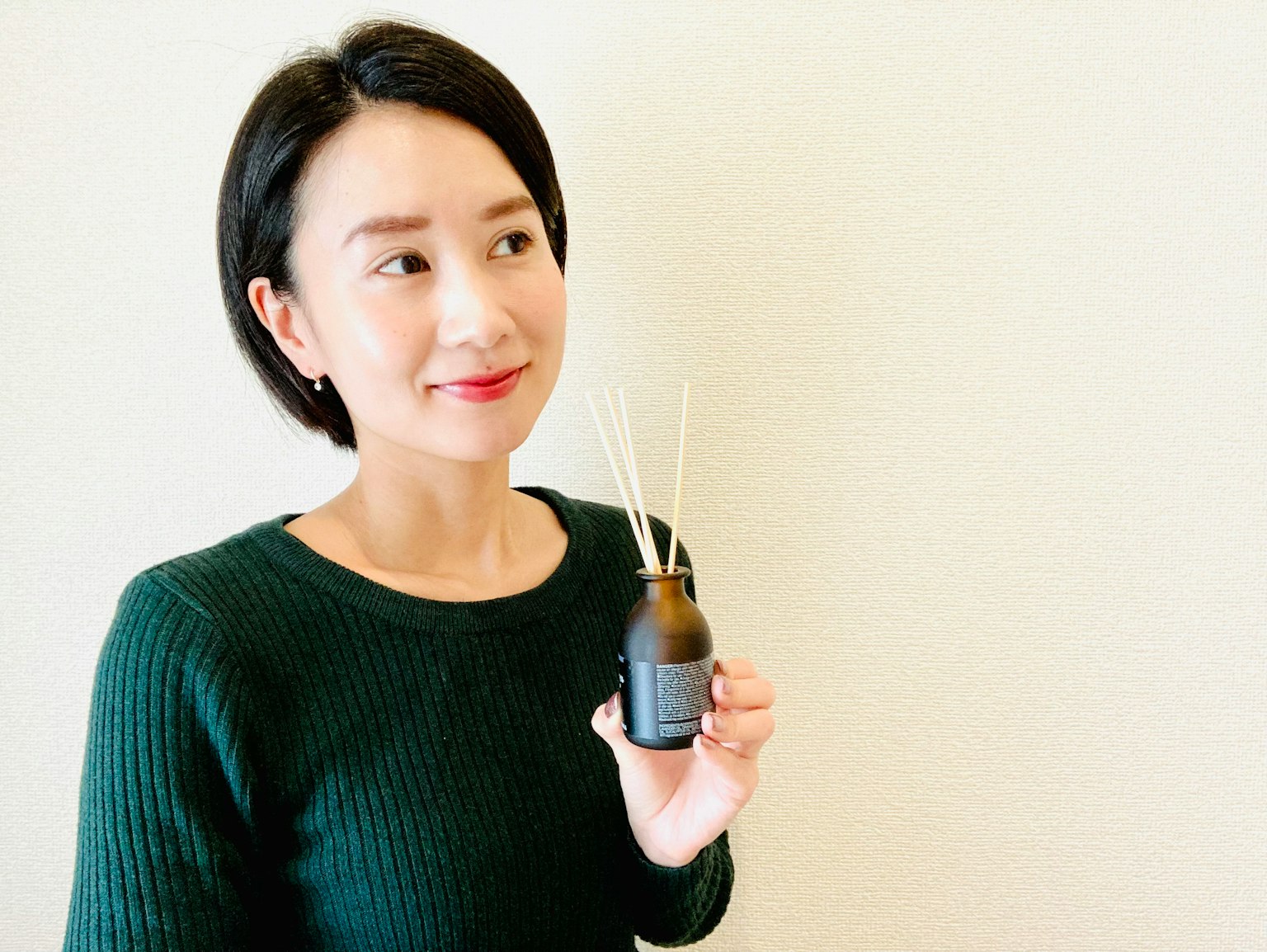 微笑的女性手持香氛擴散器和香棒