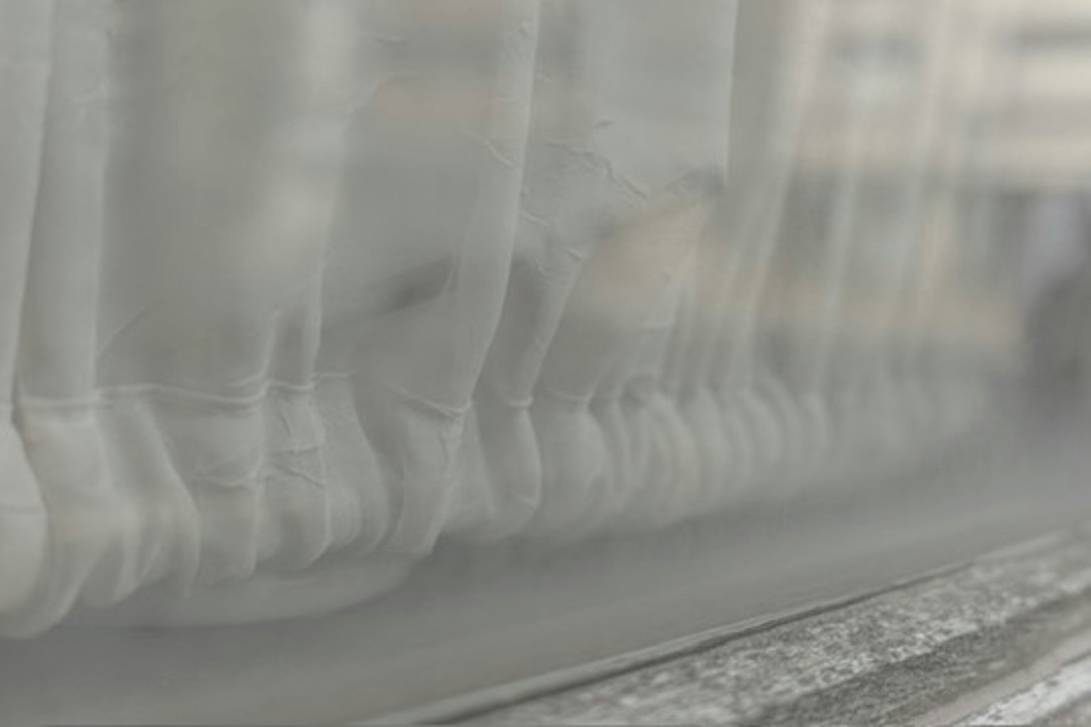 Leichter Vorhang, der am Fenster weht