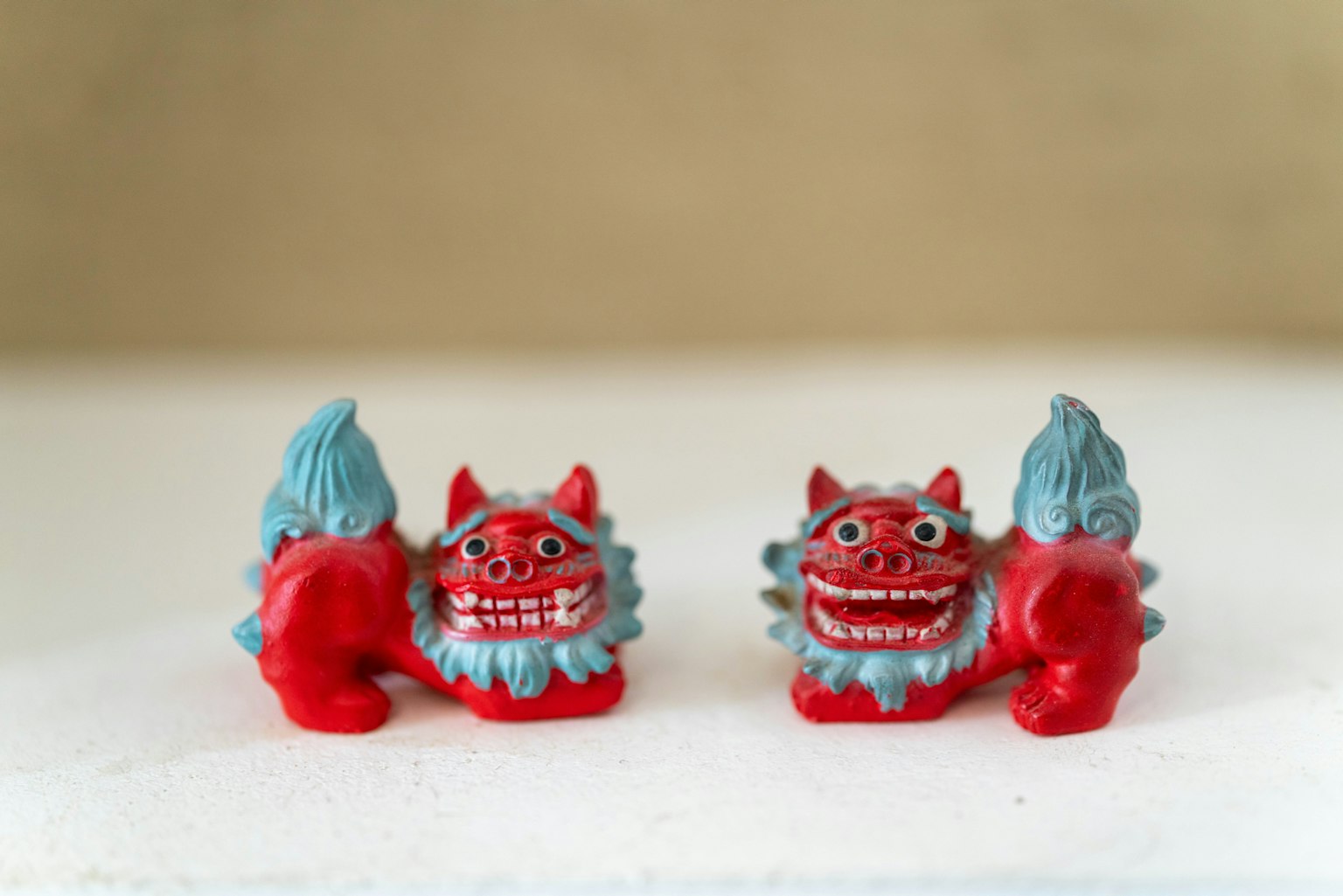 Two colorful Shisa figurines in red and blue