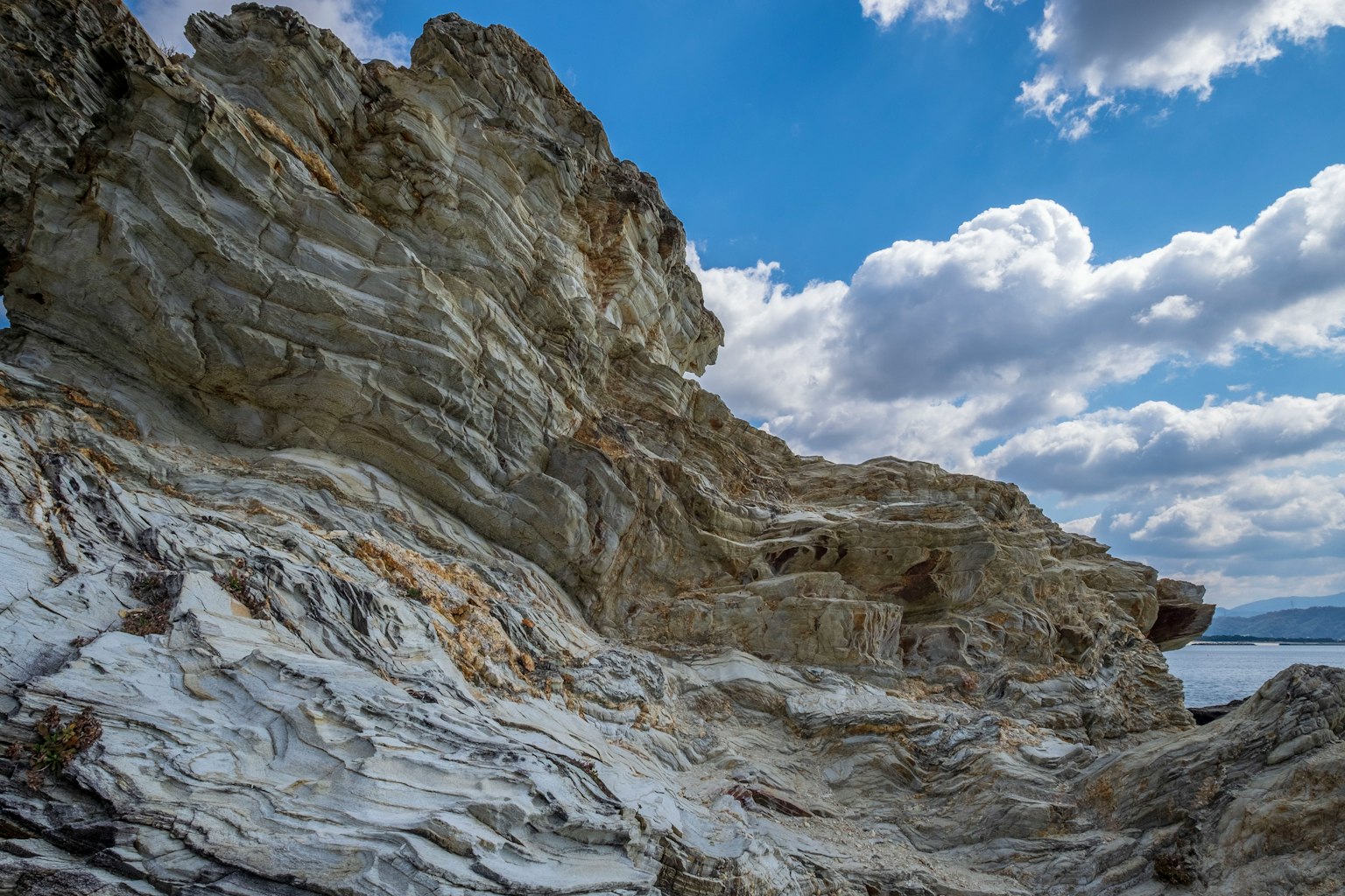 Texture détaillée des rochers côtiers sous un ciel bleu