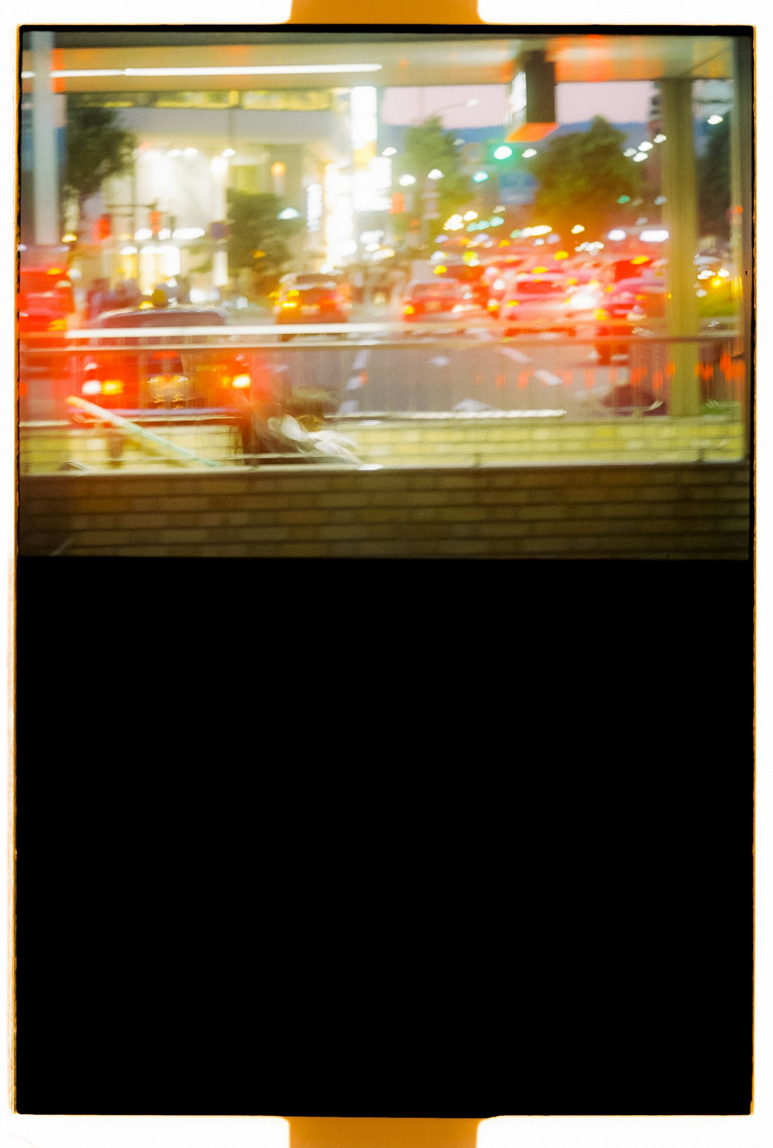 Night cityscape with glowing red car taillights and bright streetlights