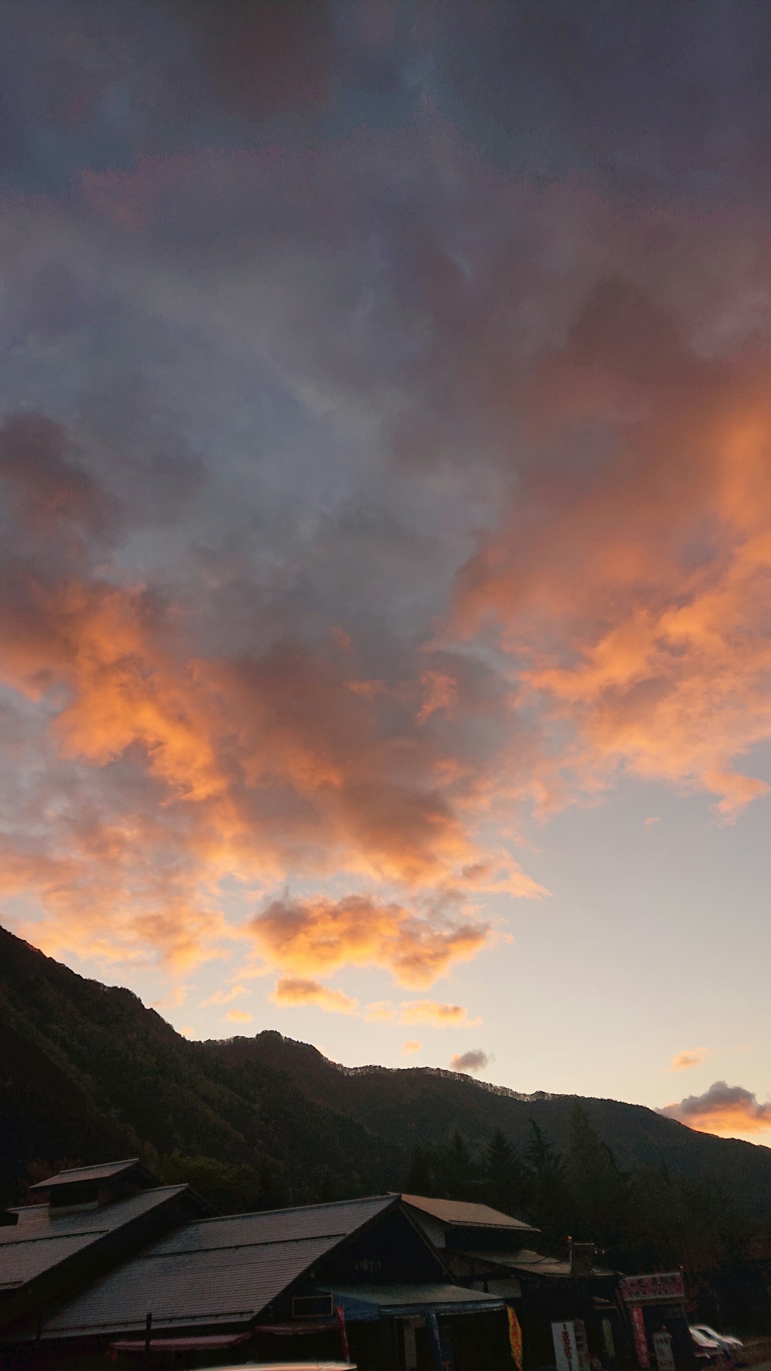 Pemandangan langit senja dengan awan oranye dan ungu