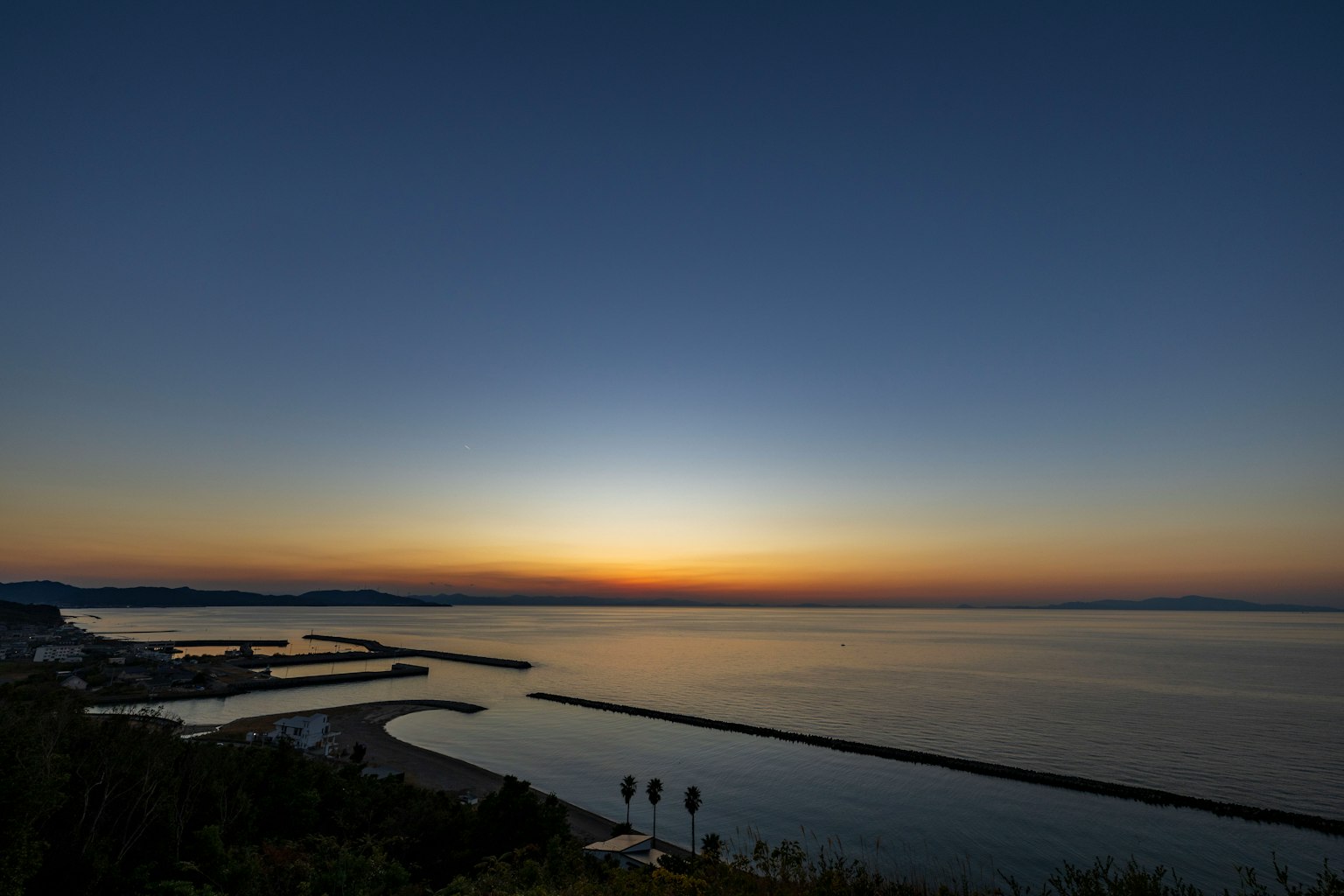 Vista panoramica dell'oceano e del porto al tramonto