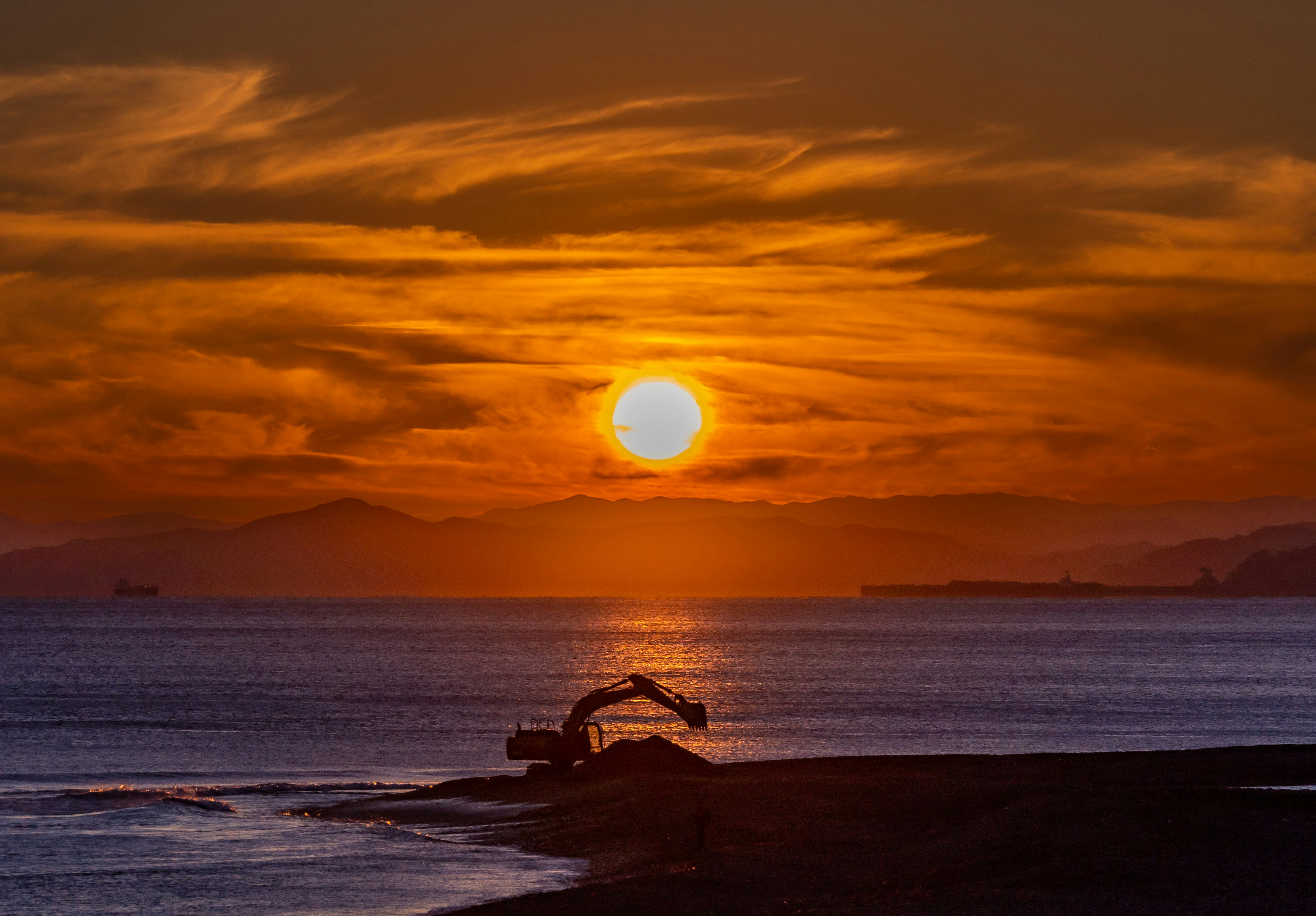 夕日に照らされる海辺の波と水平線