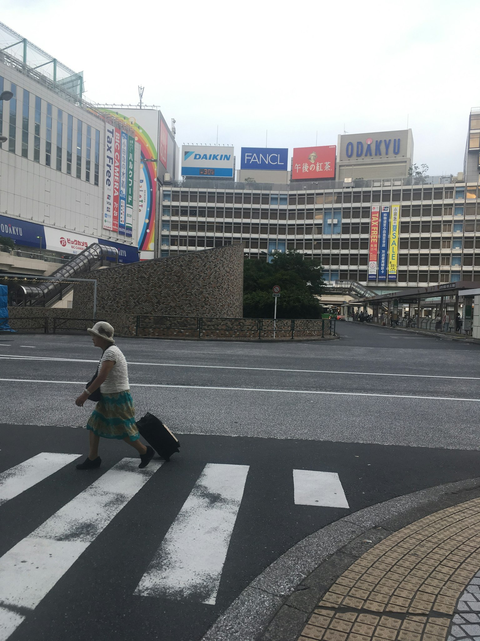 Viaggiatore che attraversa la strada con bagagli e insegne di edifici sullo sfondo