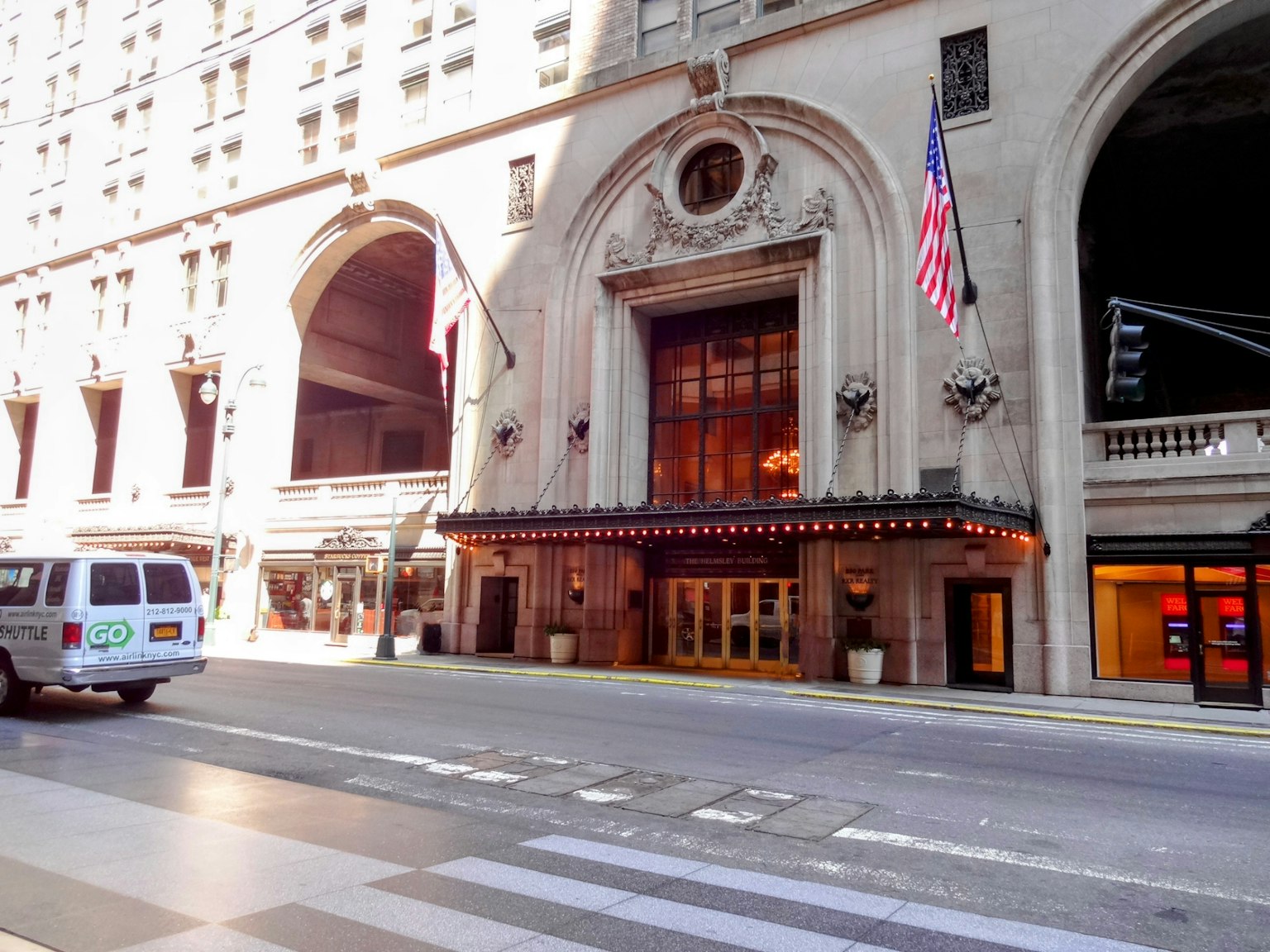 Cổng vào khách sạn lịch sử ở New York có cờ Mỹ và kiến trúc tinh xảo