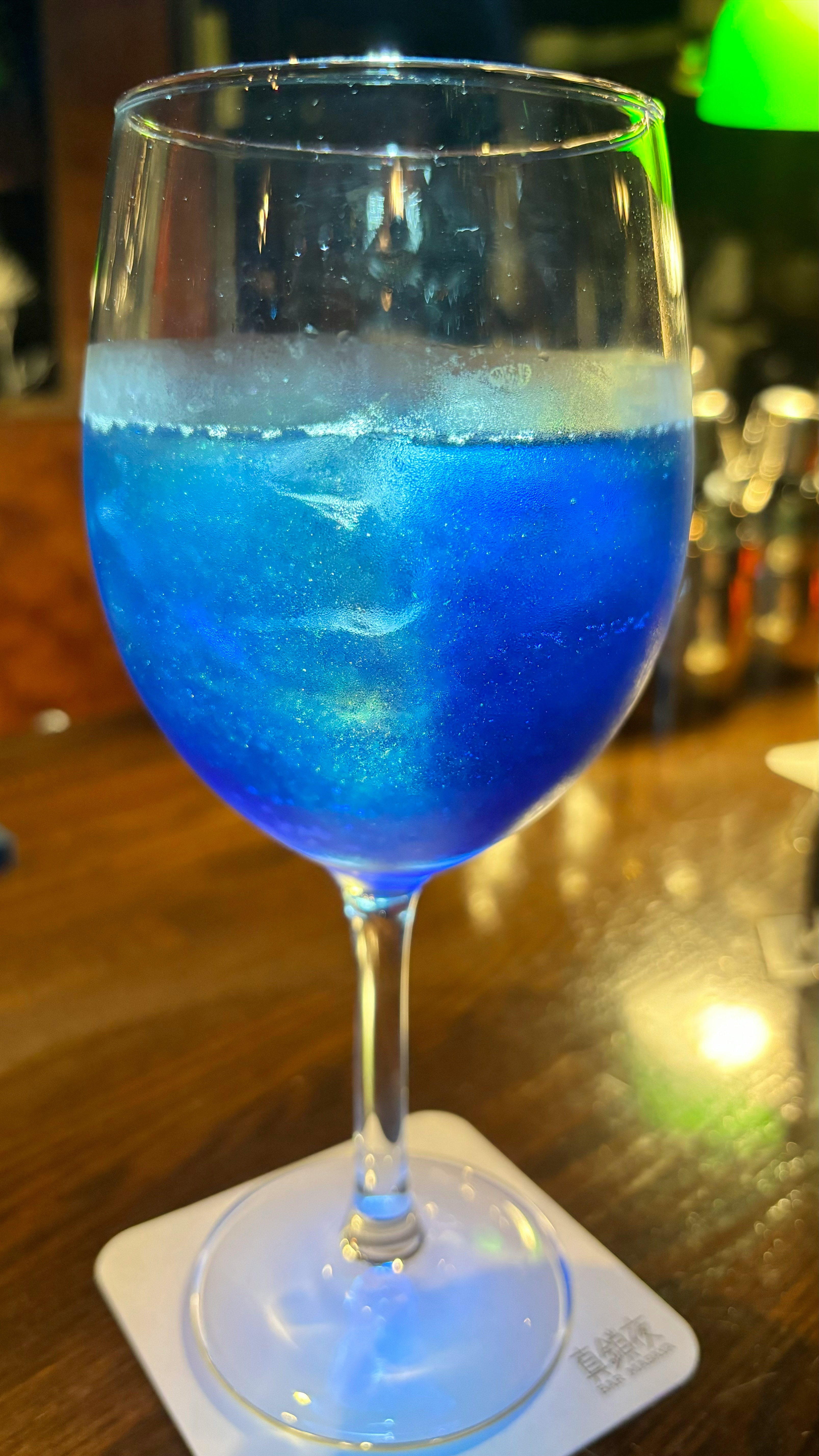 blue cocktail glass with foamy surface