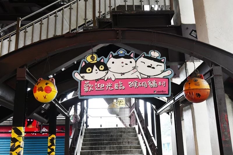 猫のモチーフが並ぶ階段アーチの看板画像