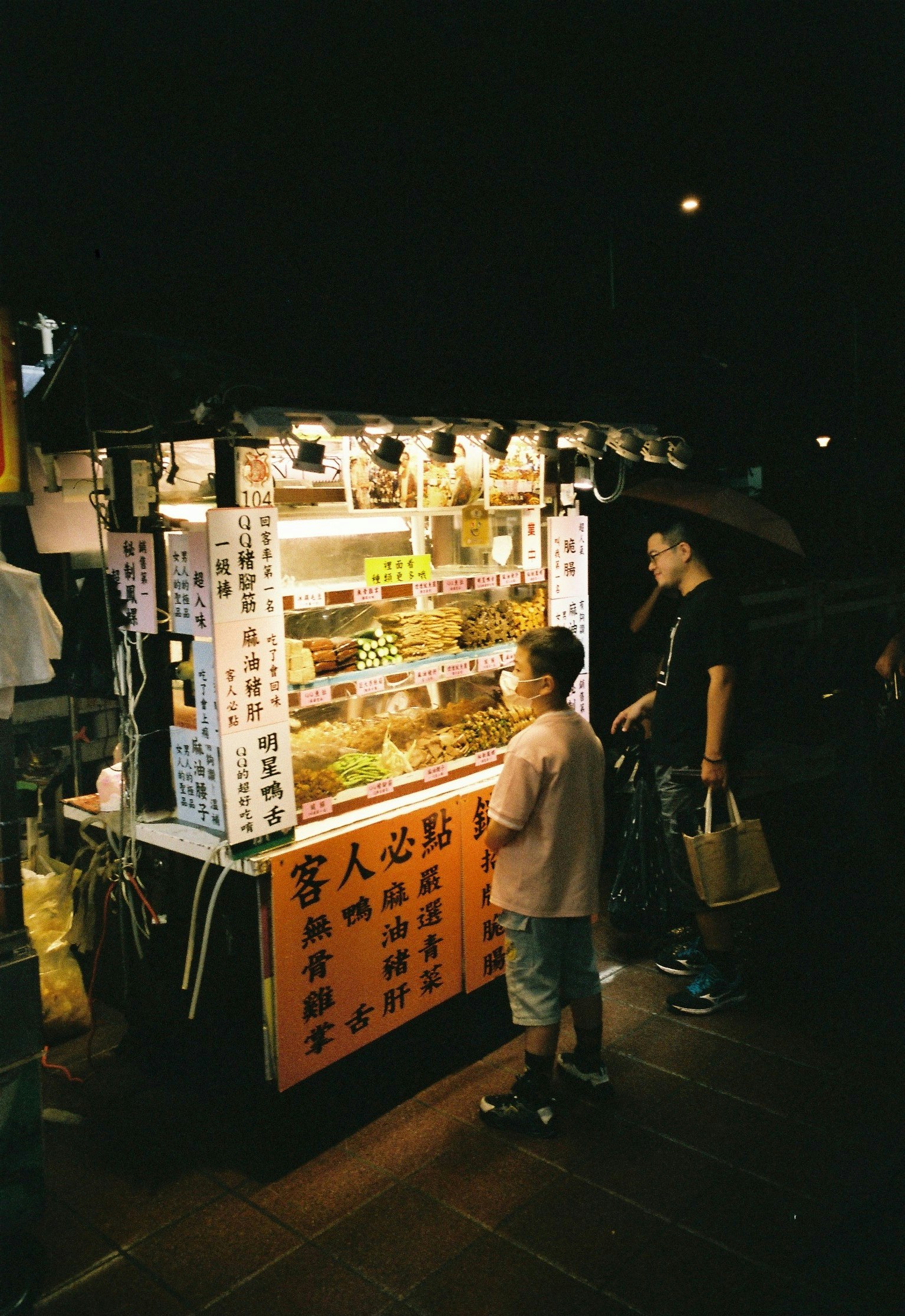 夜の屋台で並ぶ看板と人々のいる路上
