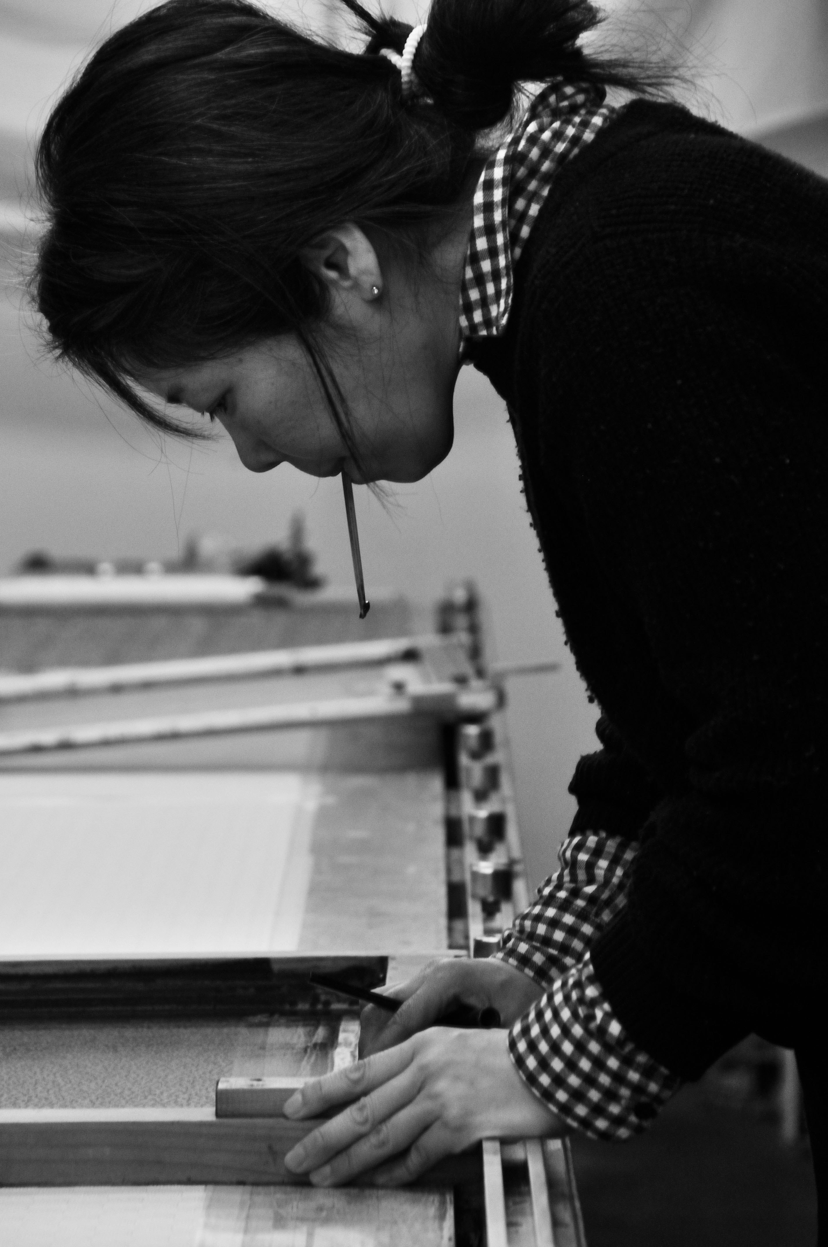 作業台で木材を手で調整する人物の横顔