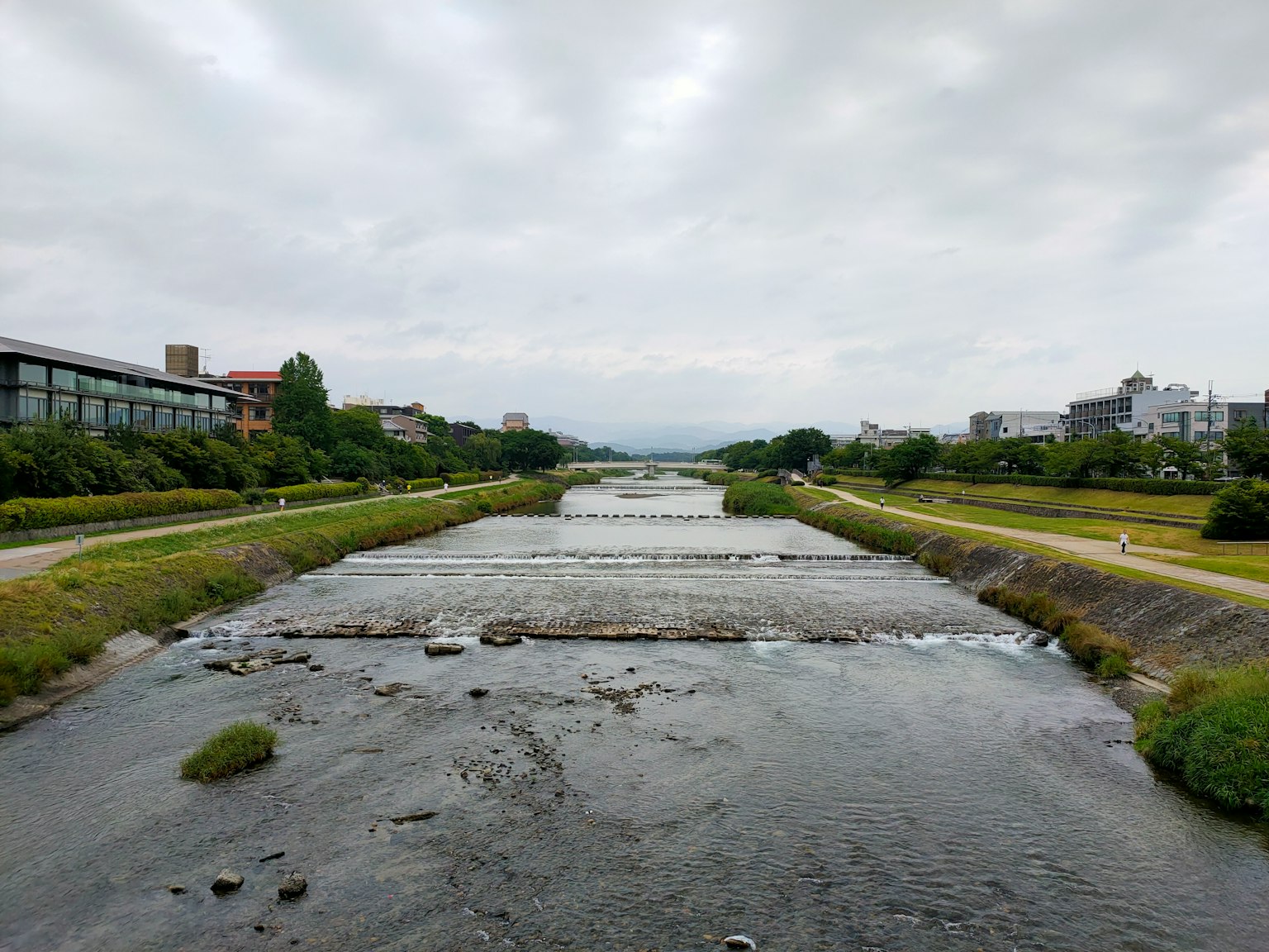 Un río sereno con vegetación circundante y cielo nublado