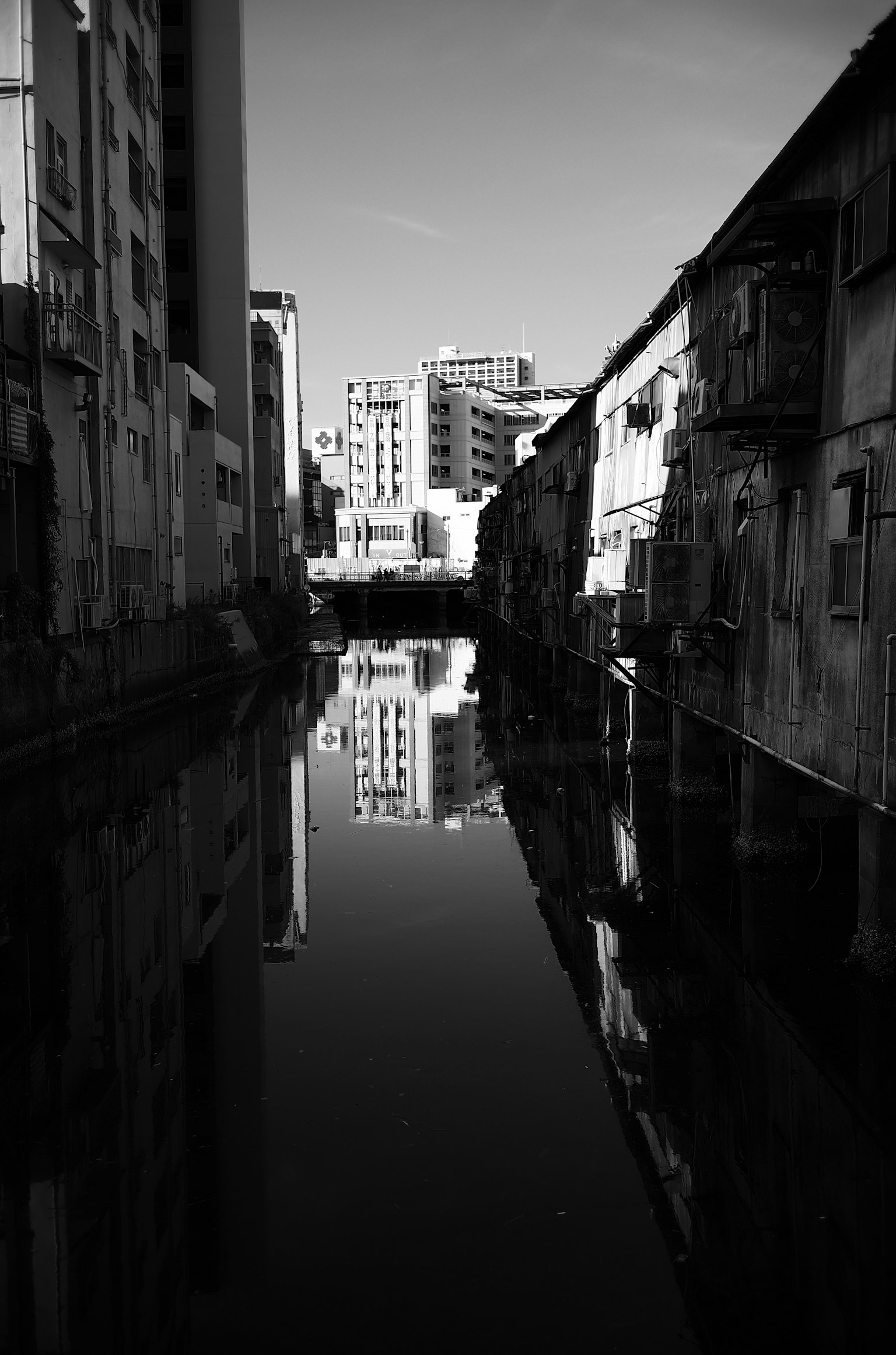 黑白城市景觀，建築物在運河中反射