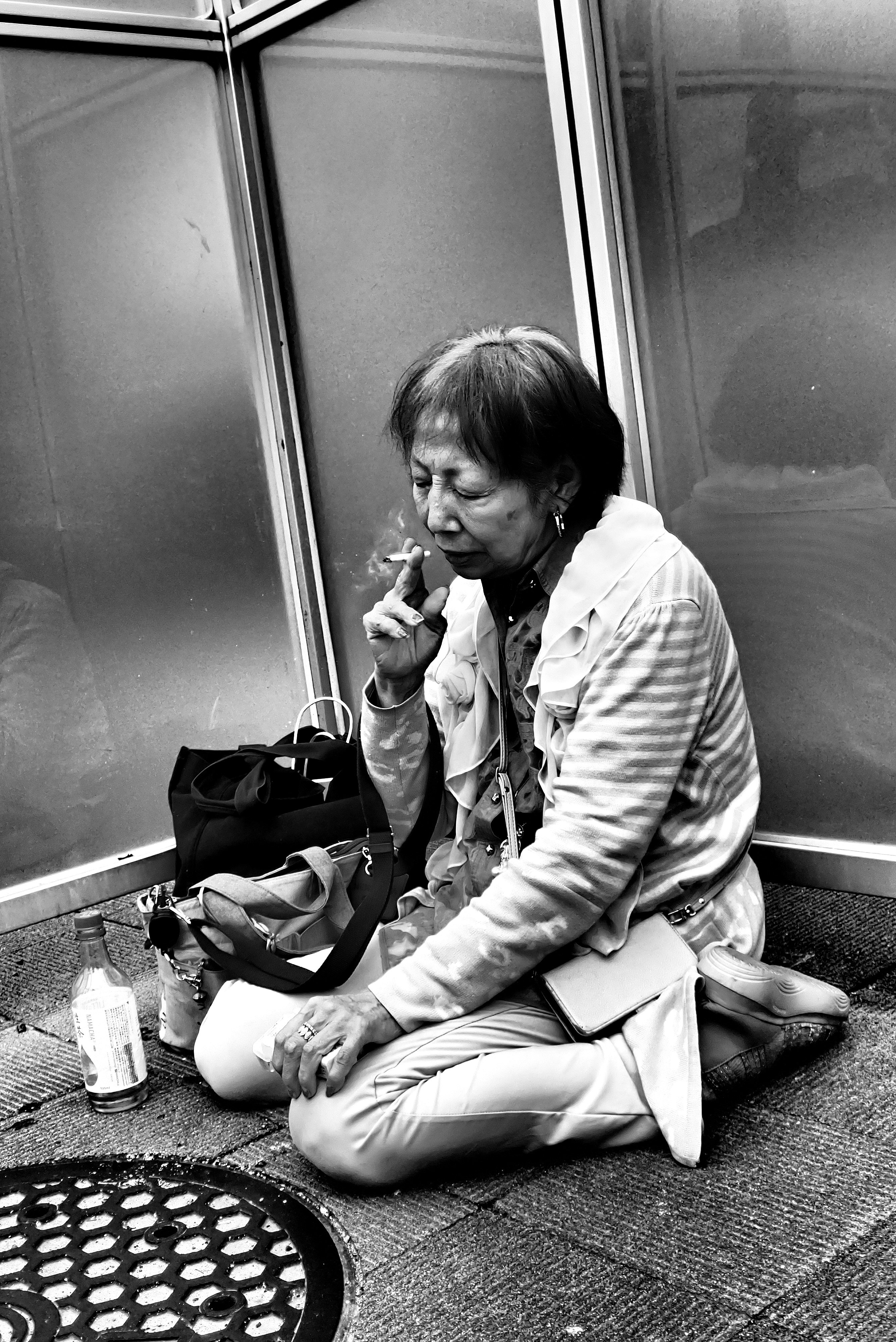 profil de femme assise sur un banc tenant un téléphone