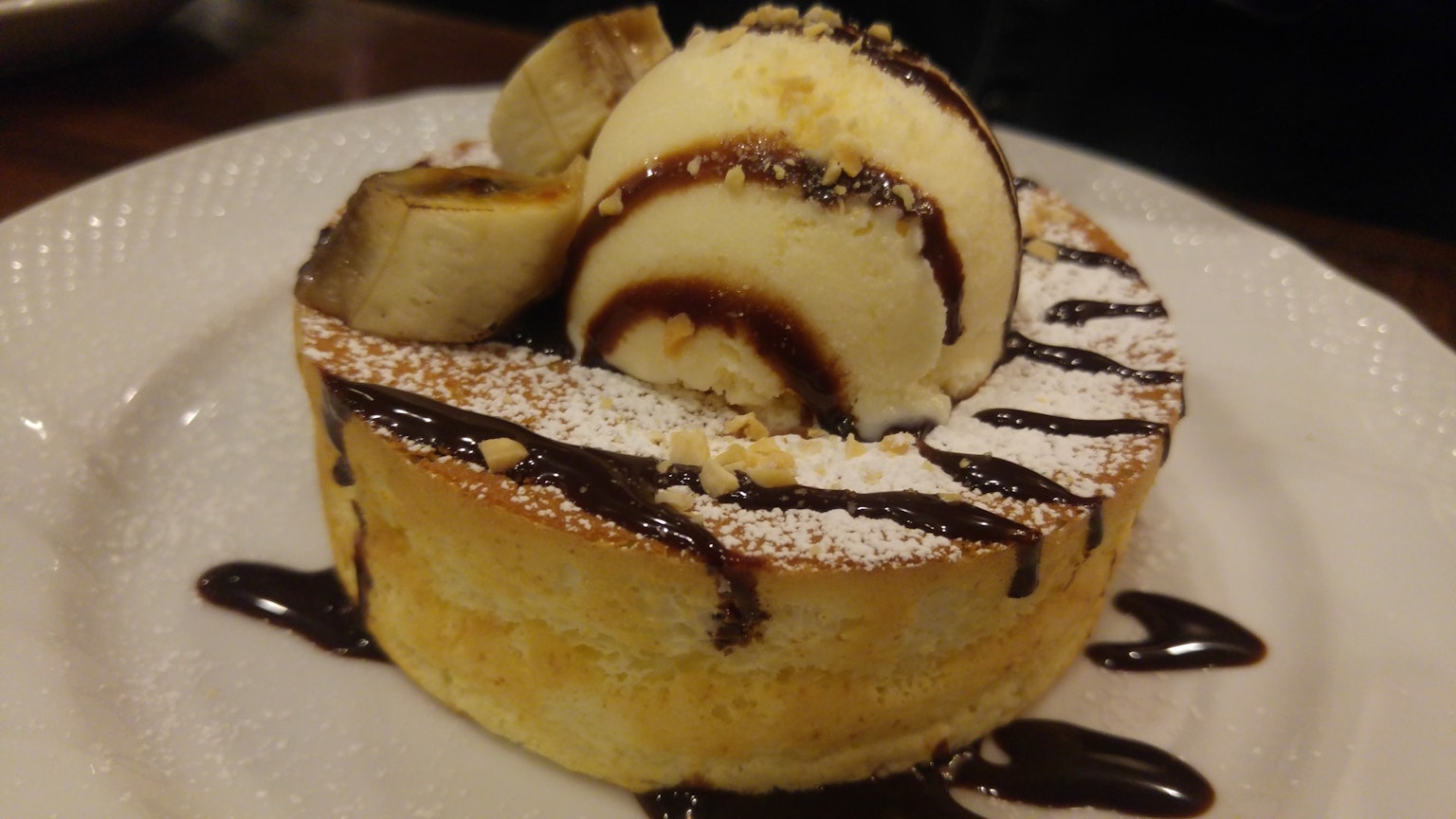 Pancake soffice guarnito con fette di banana e gelato