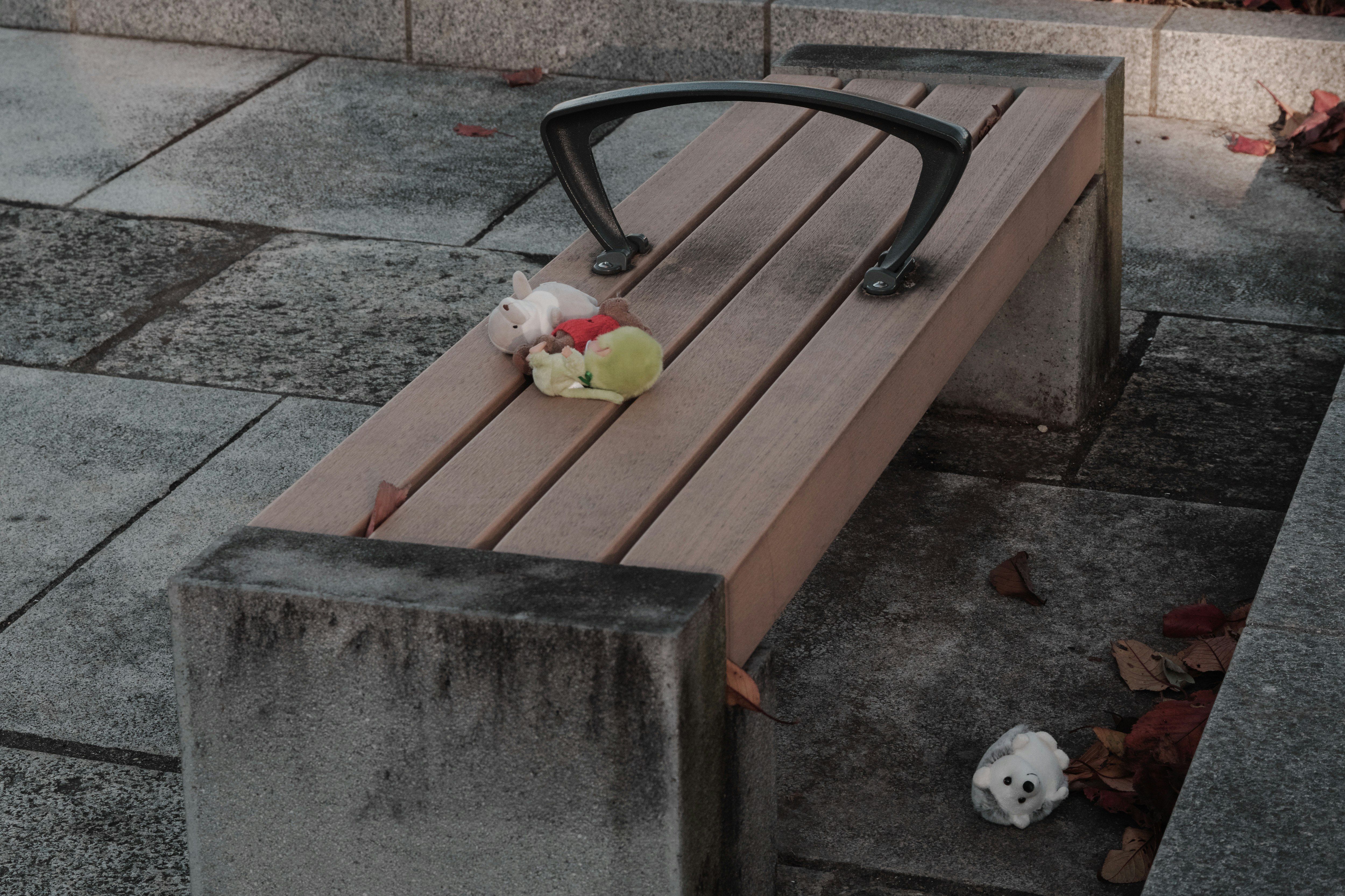広場のベンチに置かれたぬいぐるみと落としもののある街角