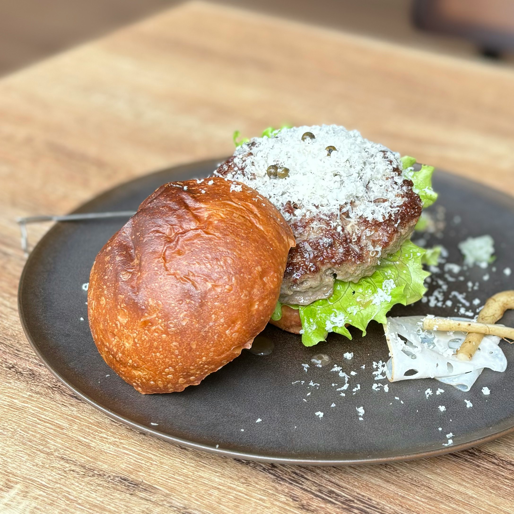 黒い皿に盛られたハンバーガーとポテトのある食卓