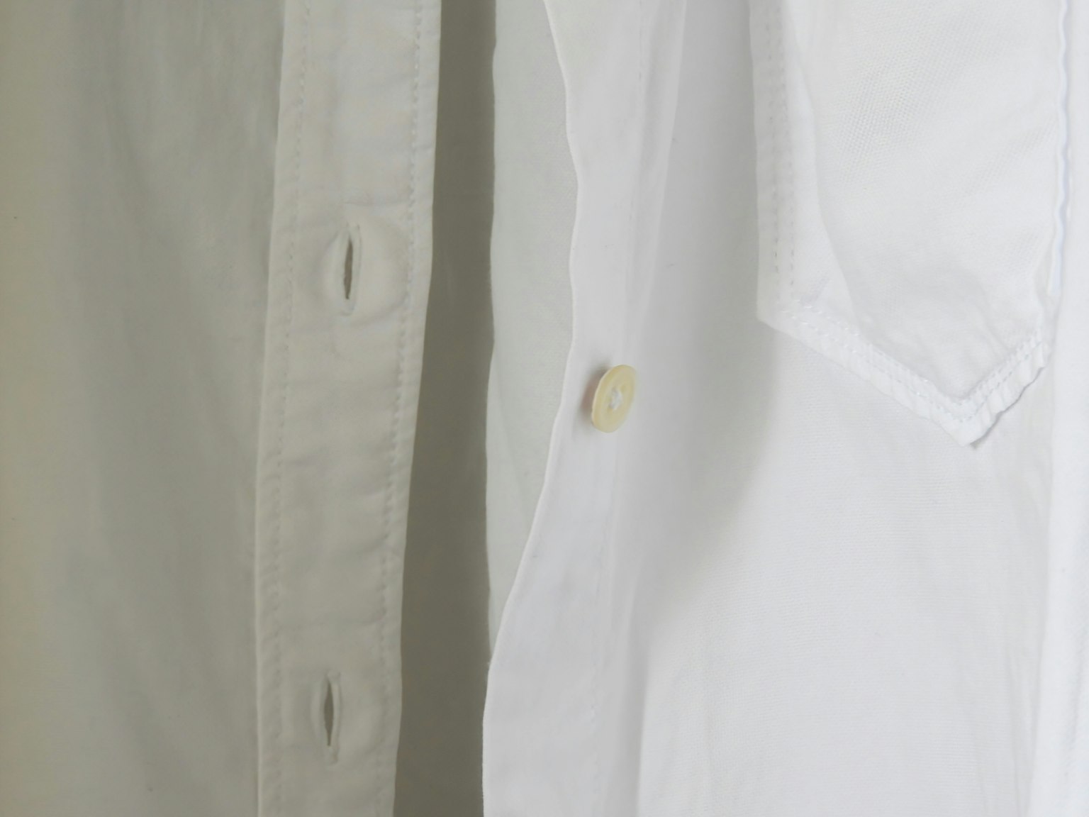 Gros plan sur une chemise blanche et une chemise grise côte à côte