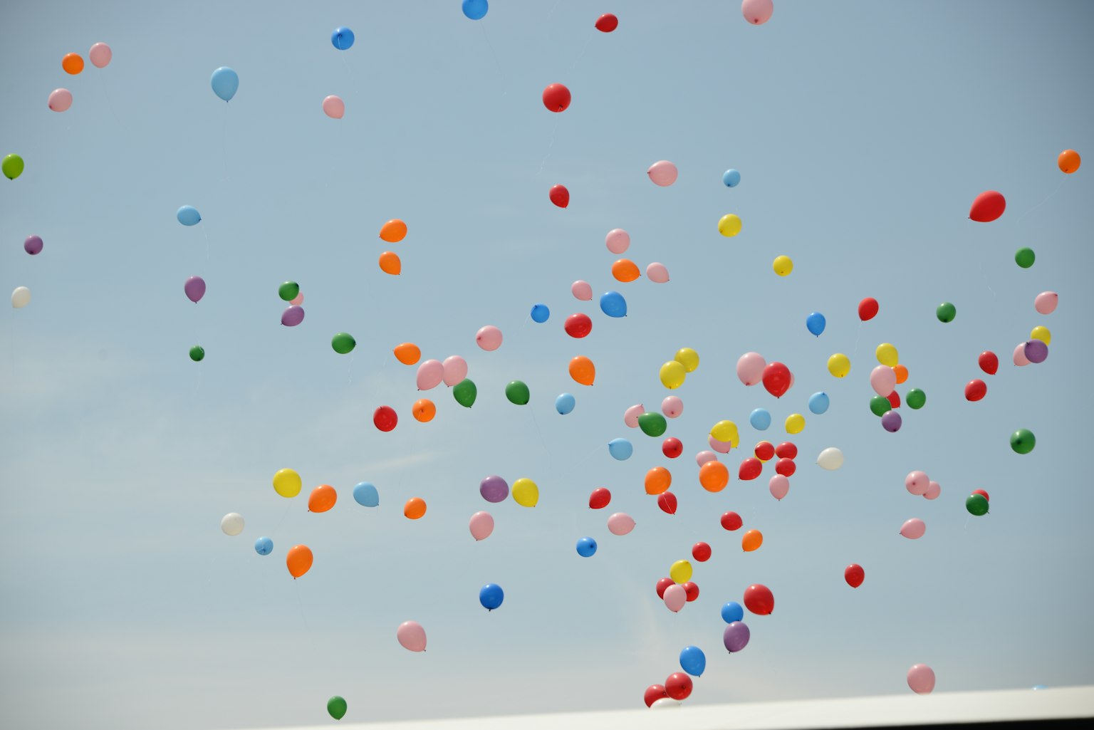 Palloni colorati che fluttuano contro un cielo blu