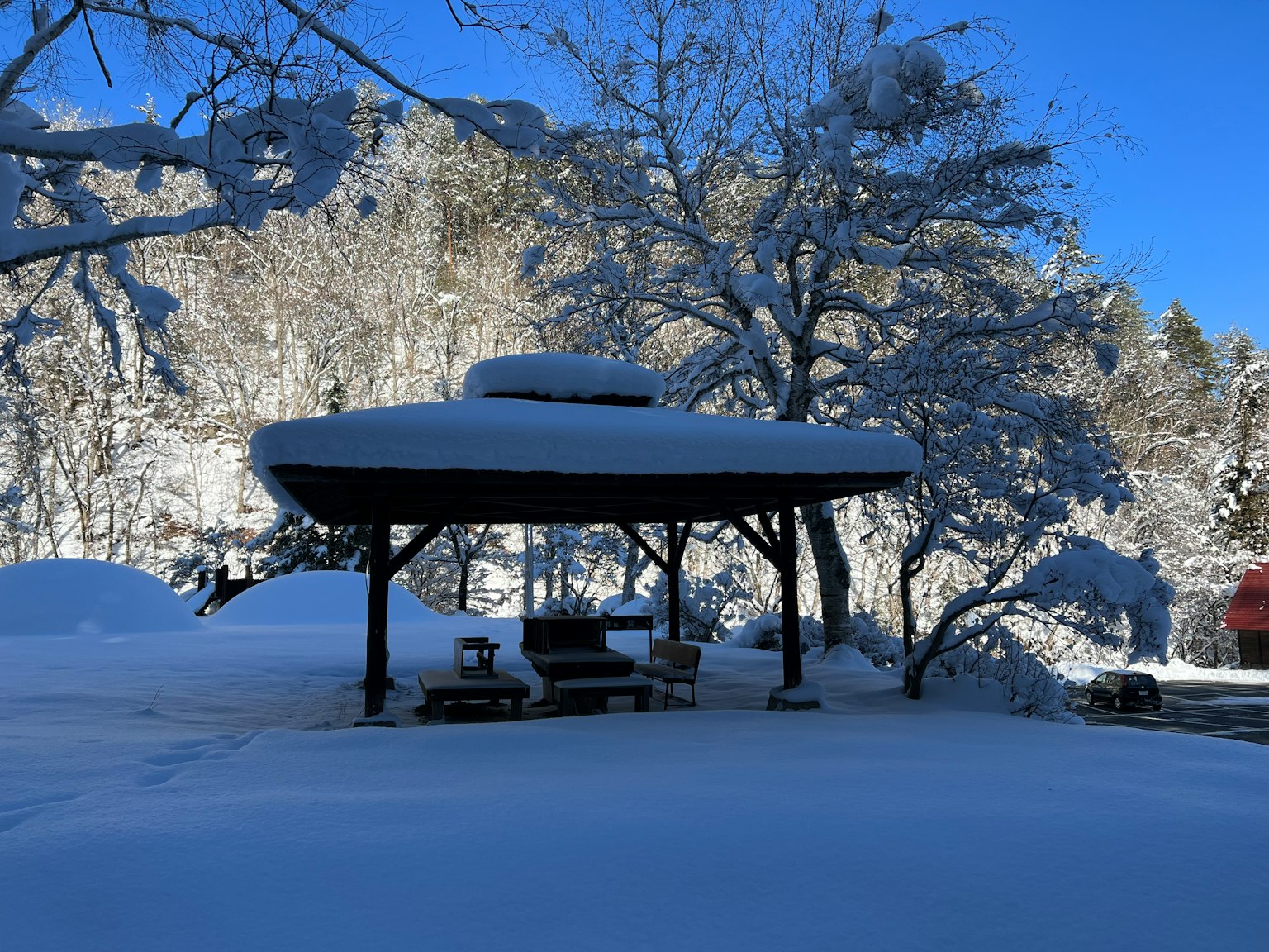 Schneebedeckter Pavillon und Bäume in einer malerischen Winterlandschaft