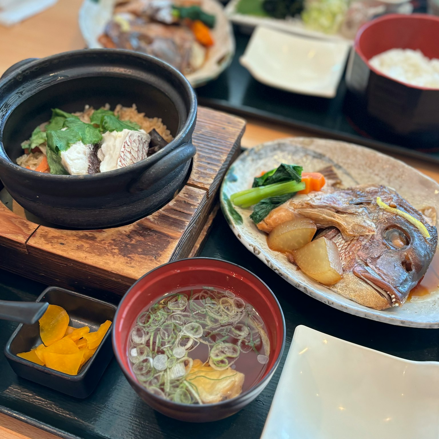 Hot pot dish with grilled fish and assorted sides beautifully presented