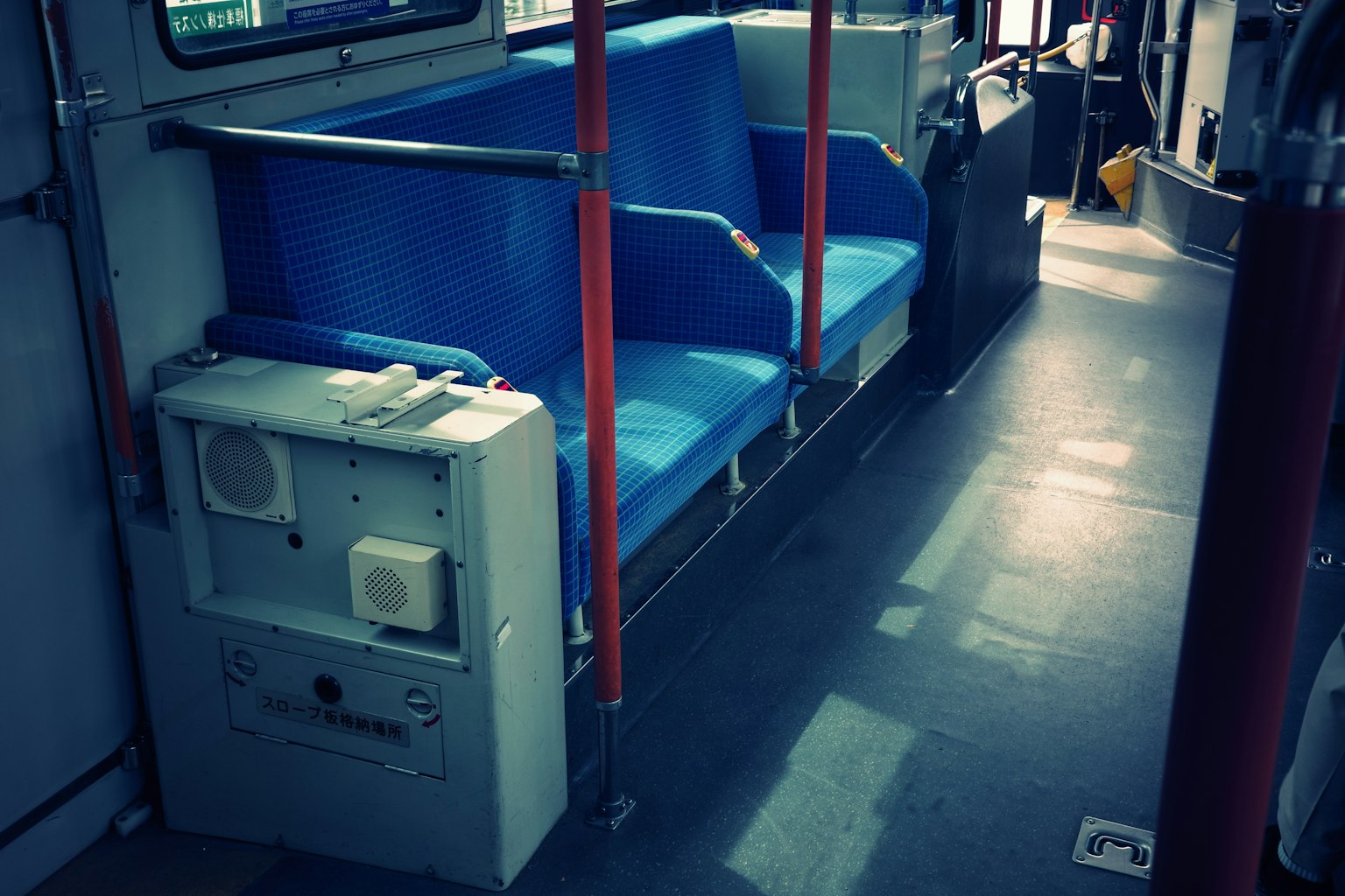 Interior of a bus featuring blue seats