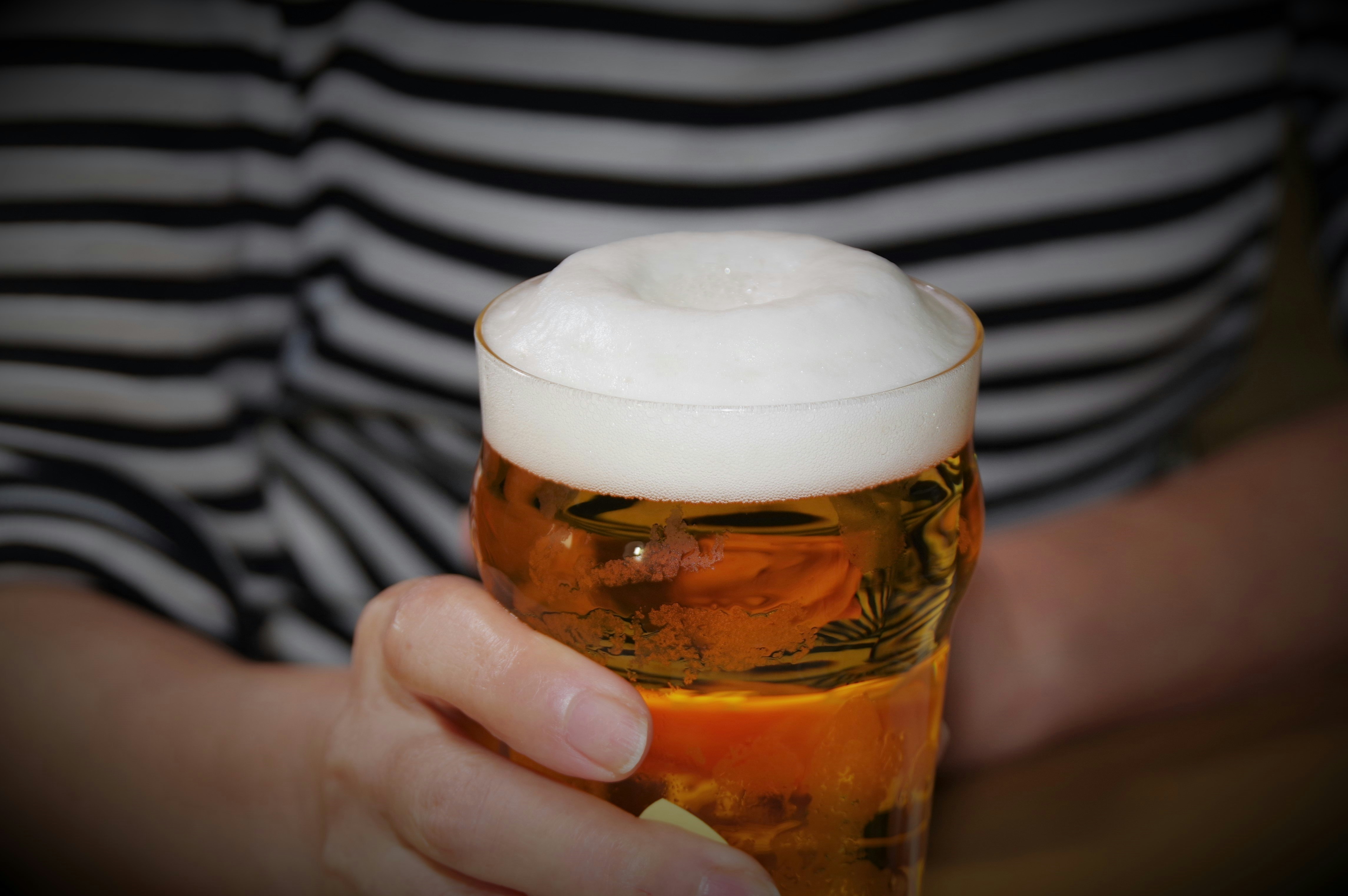 geste de trinquer avec une chope de bière mousseuse tenue à la main