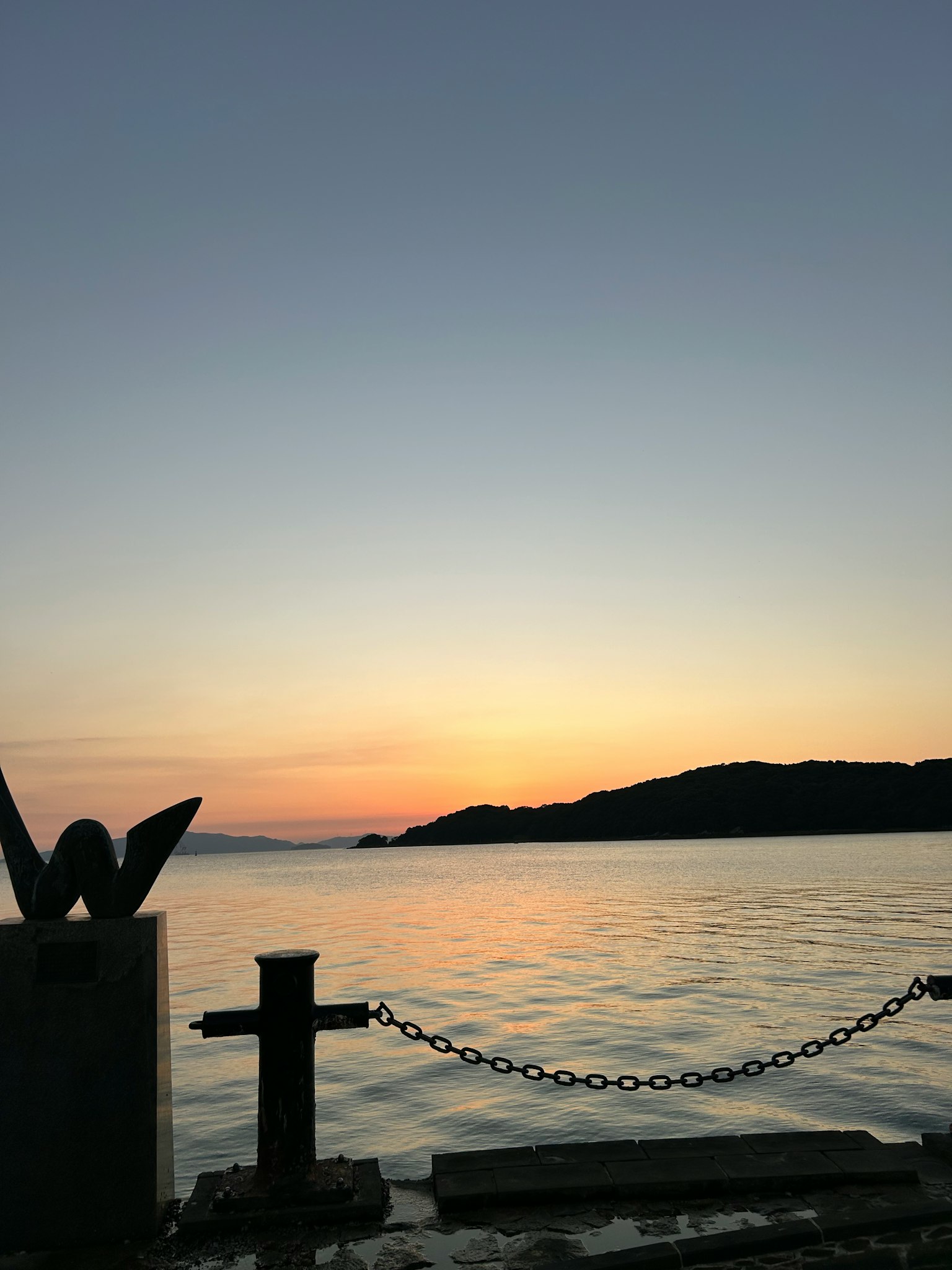 Scenic view of sunset over the sea with island silhouette