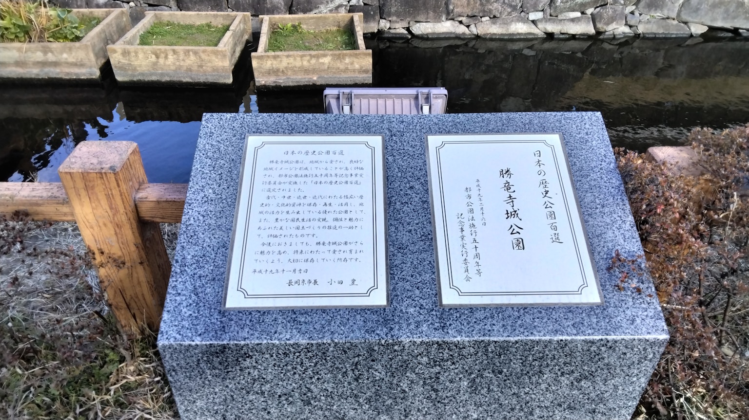 Placa de piedra con inscripciones y elemento acuático circundante