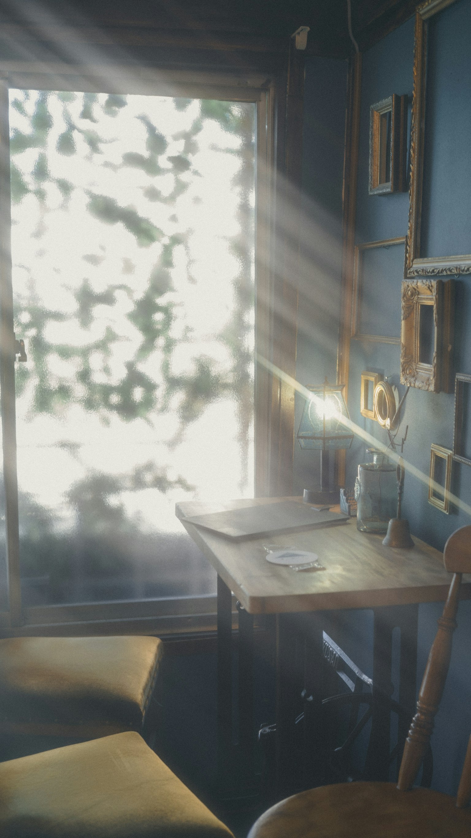 明るい光が差し込む小さな部屋のテーブルと椅子の風景