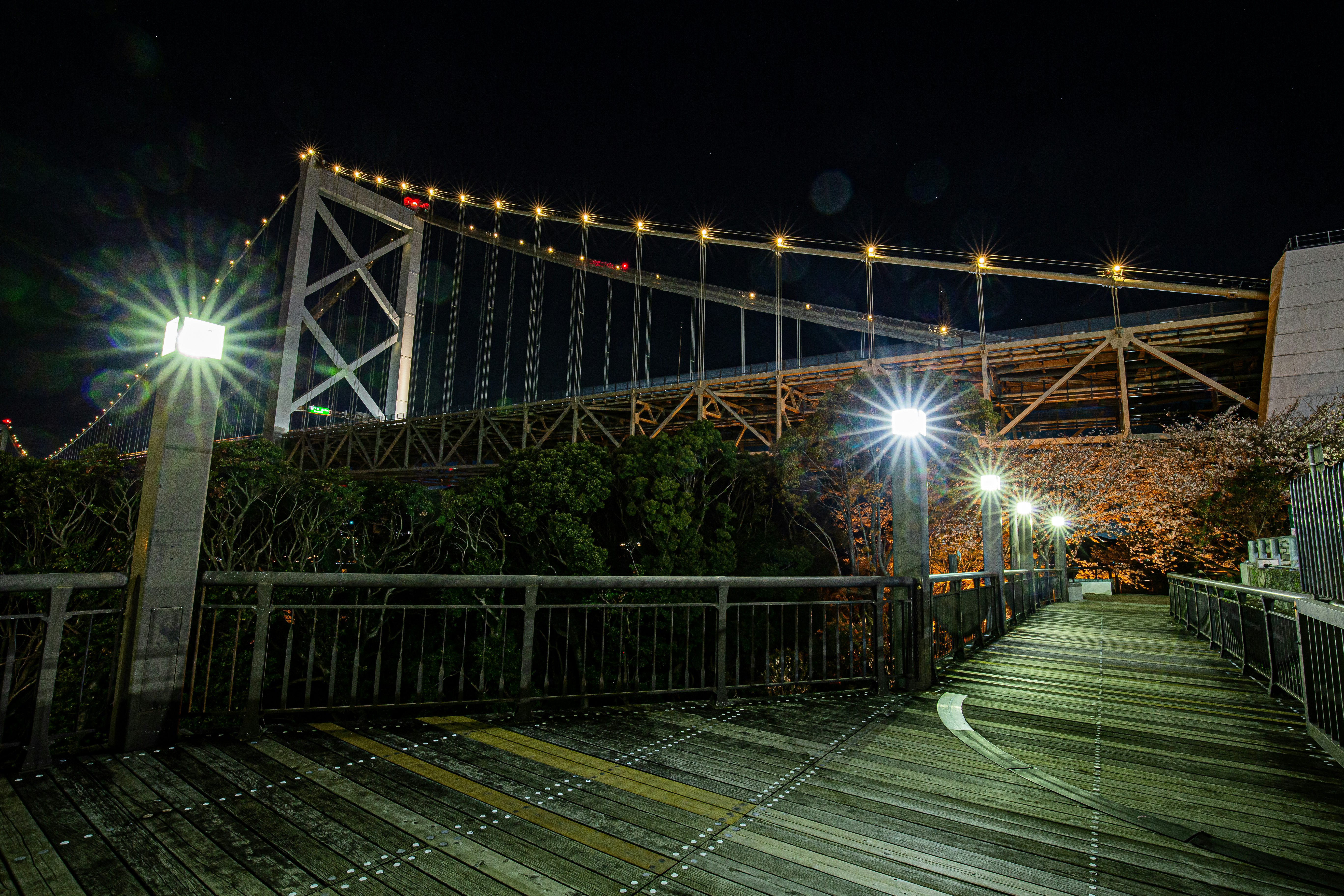 pont illuminé la nuit et promenade