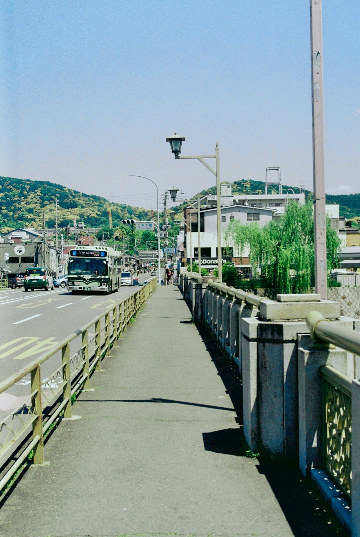 川沿いの高架道路を走るバスと車のある風景