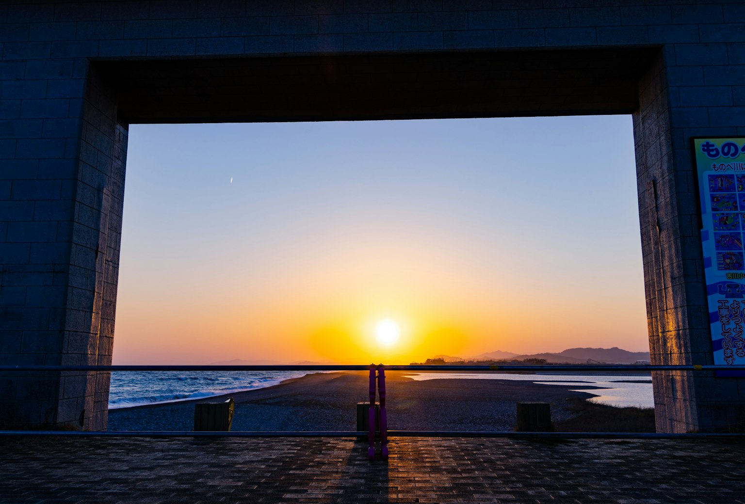 Hermosa vista del mar y la puesta de sol enmarcada por un arco