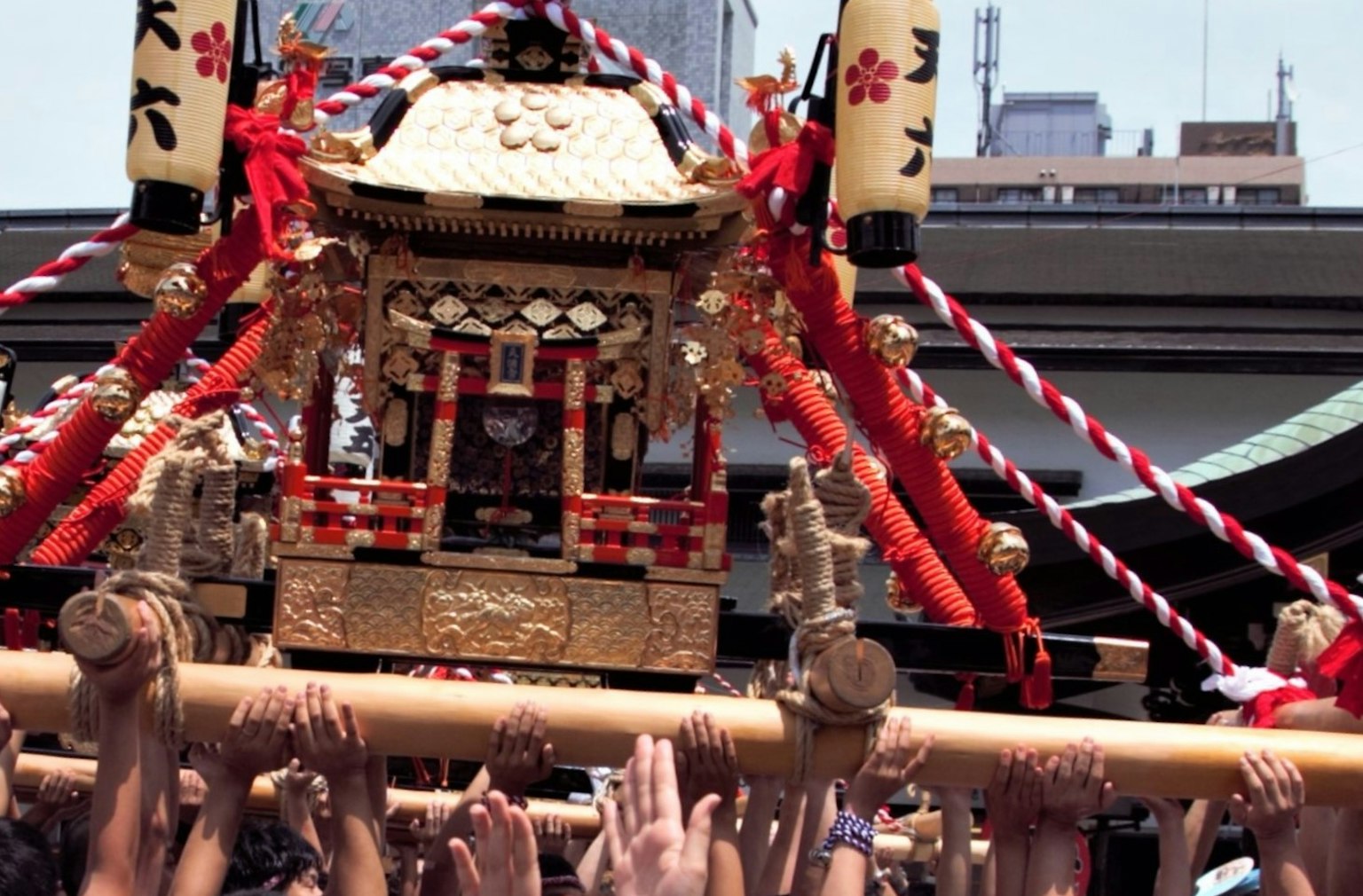 Crowd carrying a decorative mikoshi during a festival