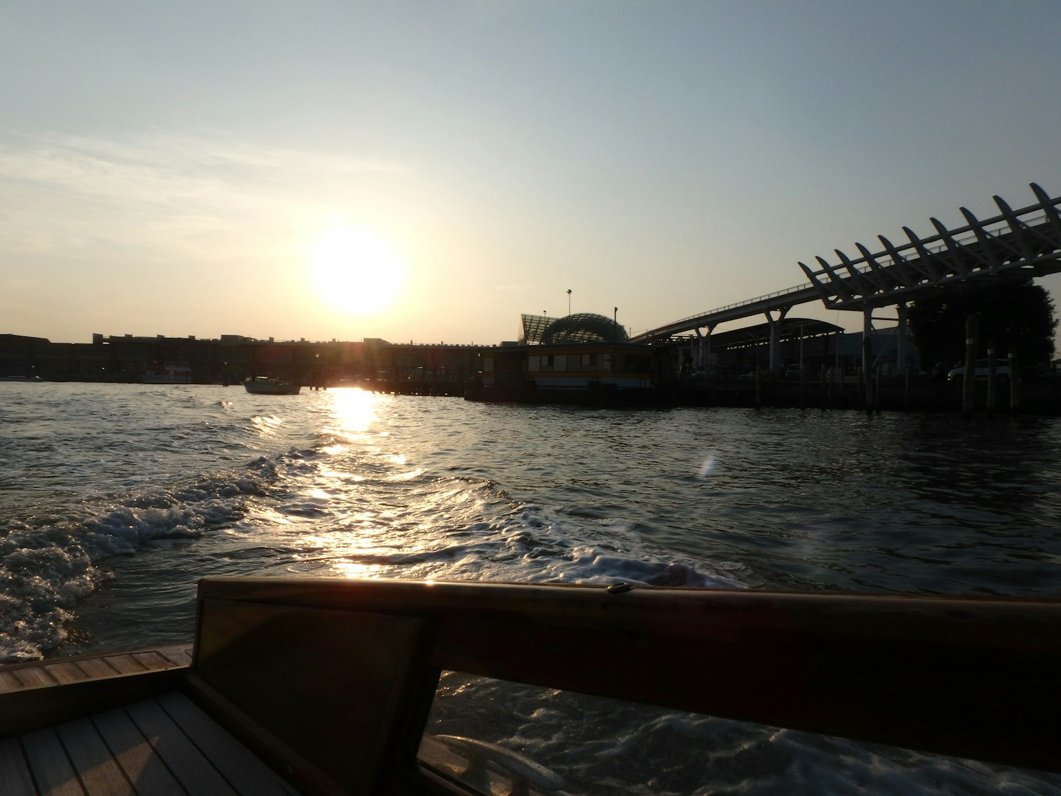 Pemandangan pelabuhan saat matahari terbenam dari perahu dengan pantulan di air