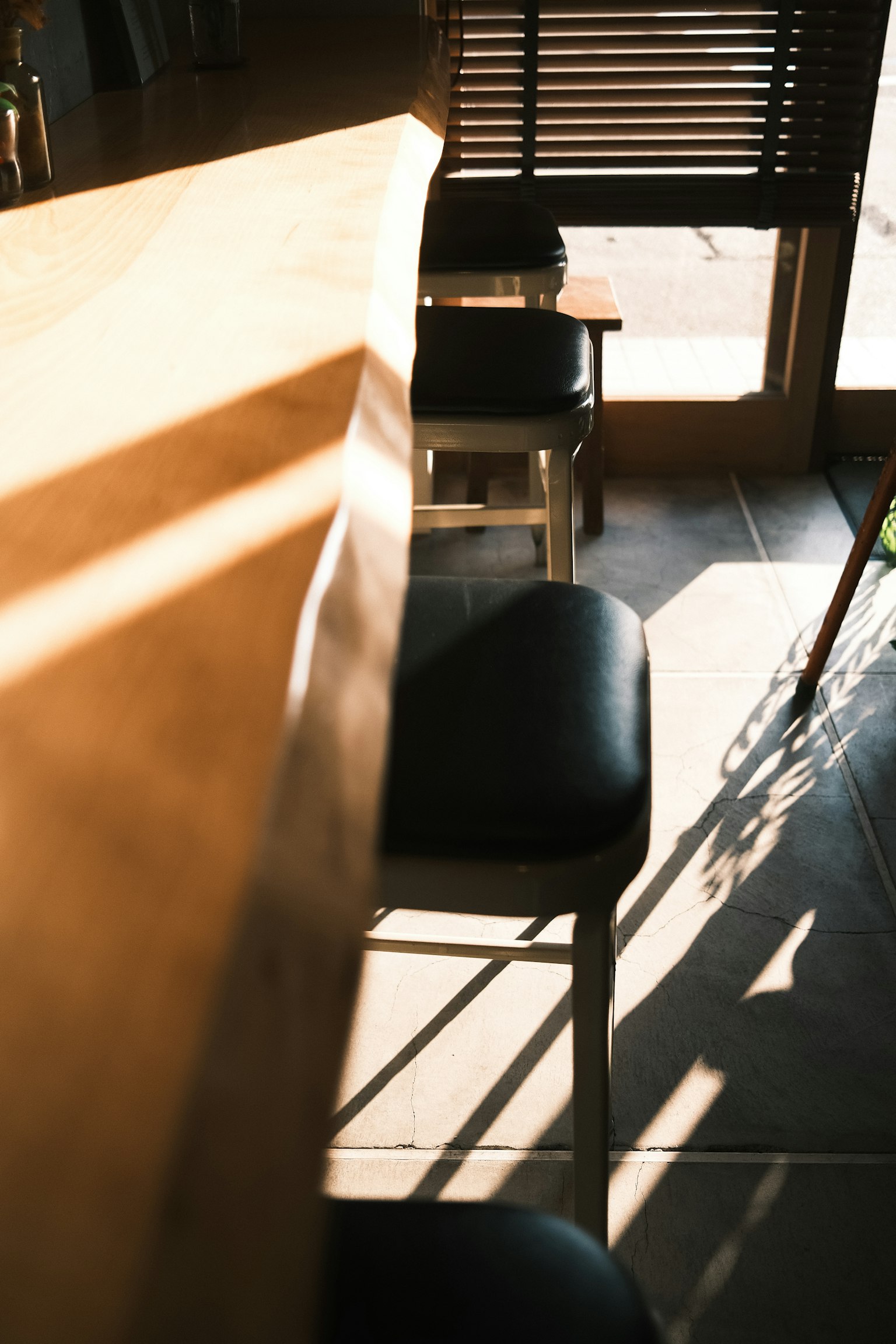 Interior kafe dengan meja kayu dan kursi hitam