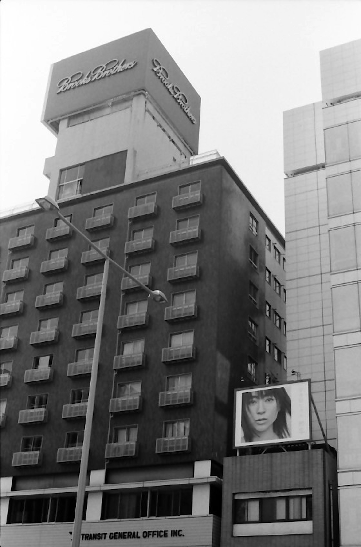 黑白照片展示了建築外觀和大型廣告