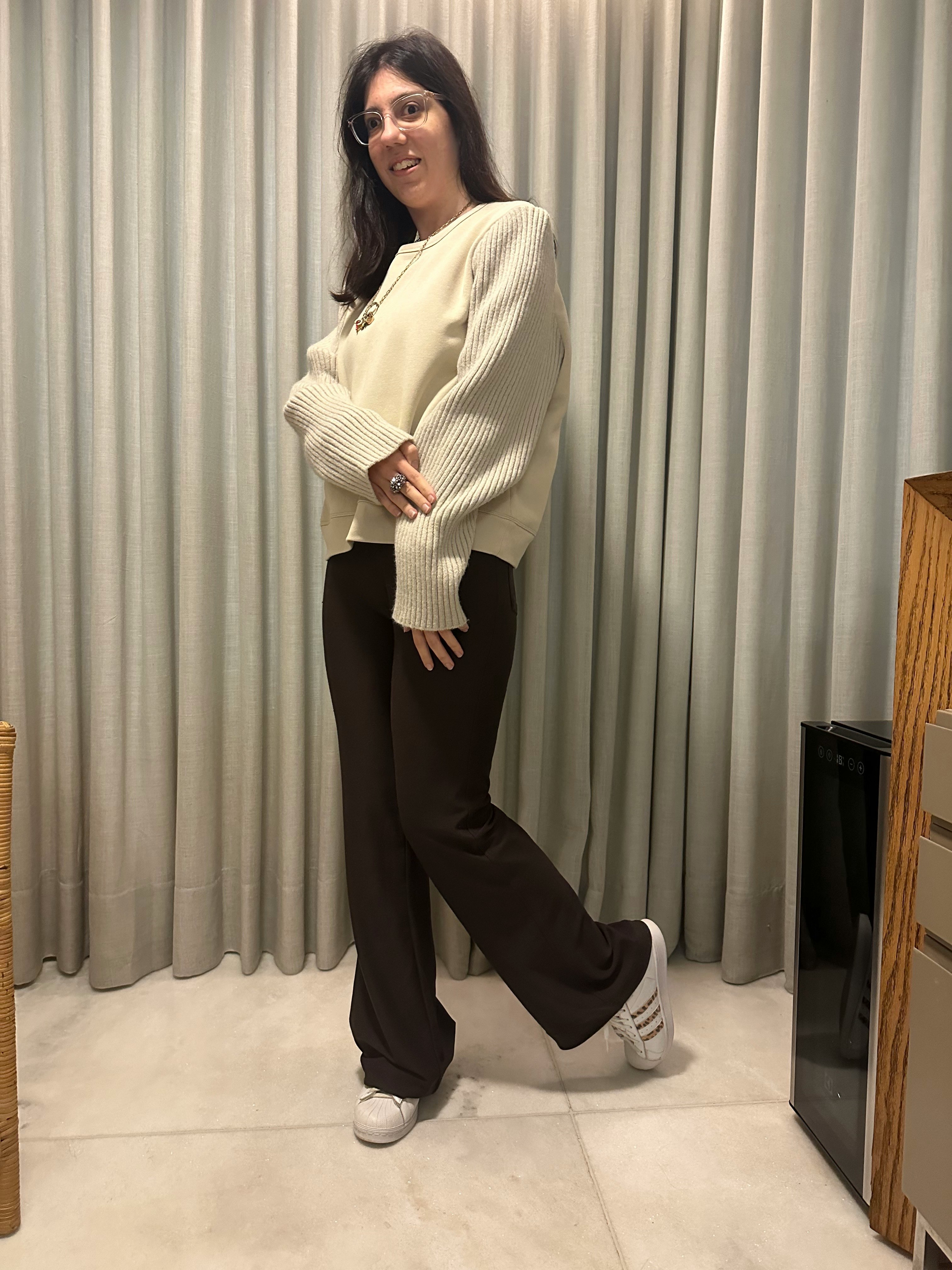 カーテン前でポーズをとる女性の全身