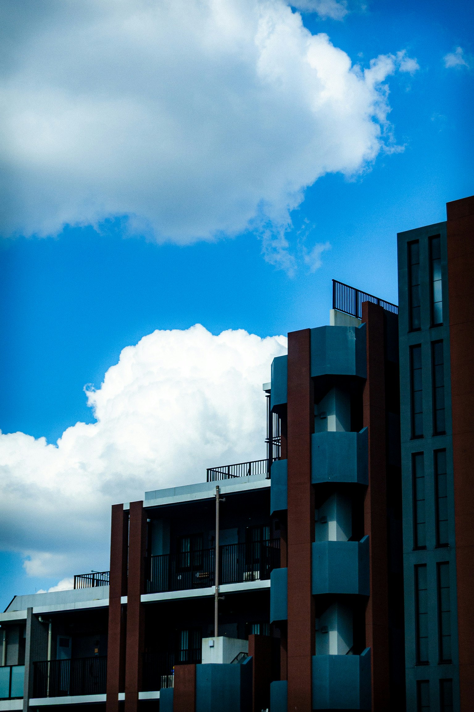Exterior de un edificio moderno bajo un cielo azul con nubes