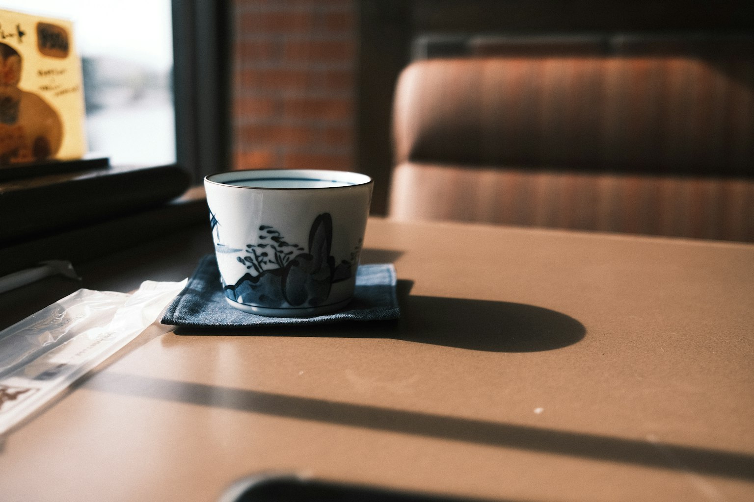 桌上的藍色圖案茶杯和碟子陽光從窗戶射進來
