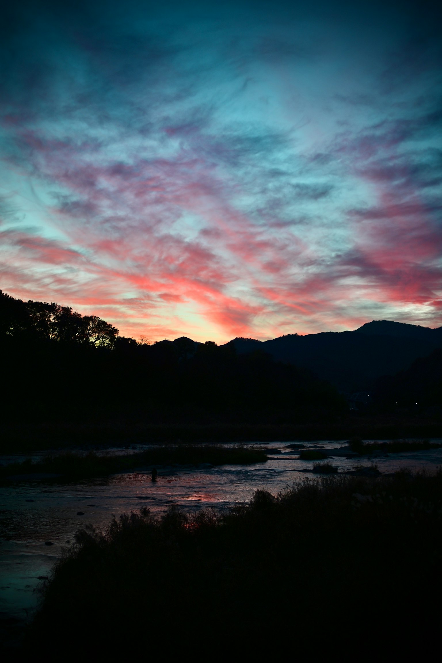 美しい夕焼けの空と山々のシルエットが映る風景