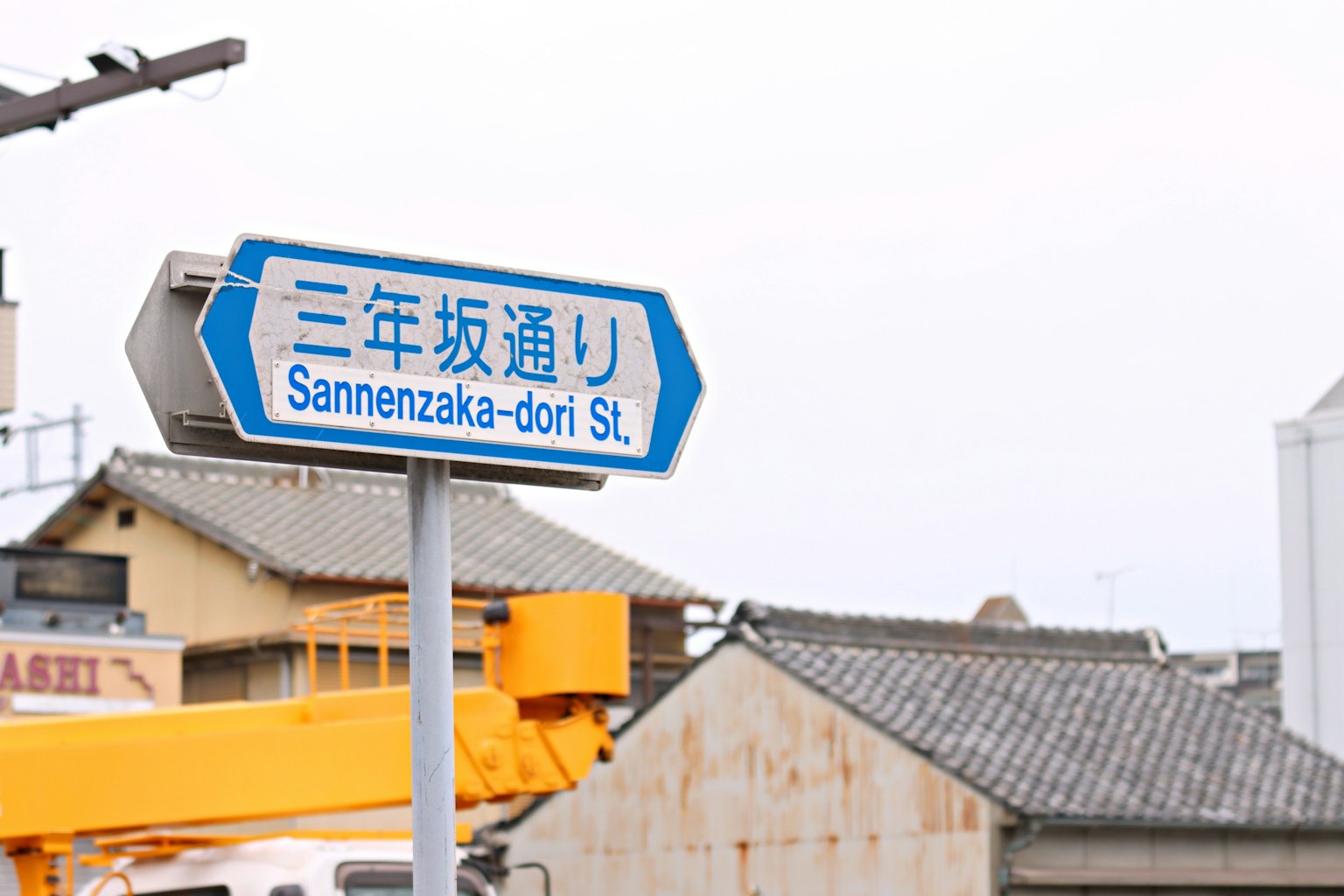 Cartel de calle azul para Sannenzaka-dori St con arquitectura japonesa tradicional al fondo