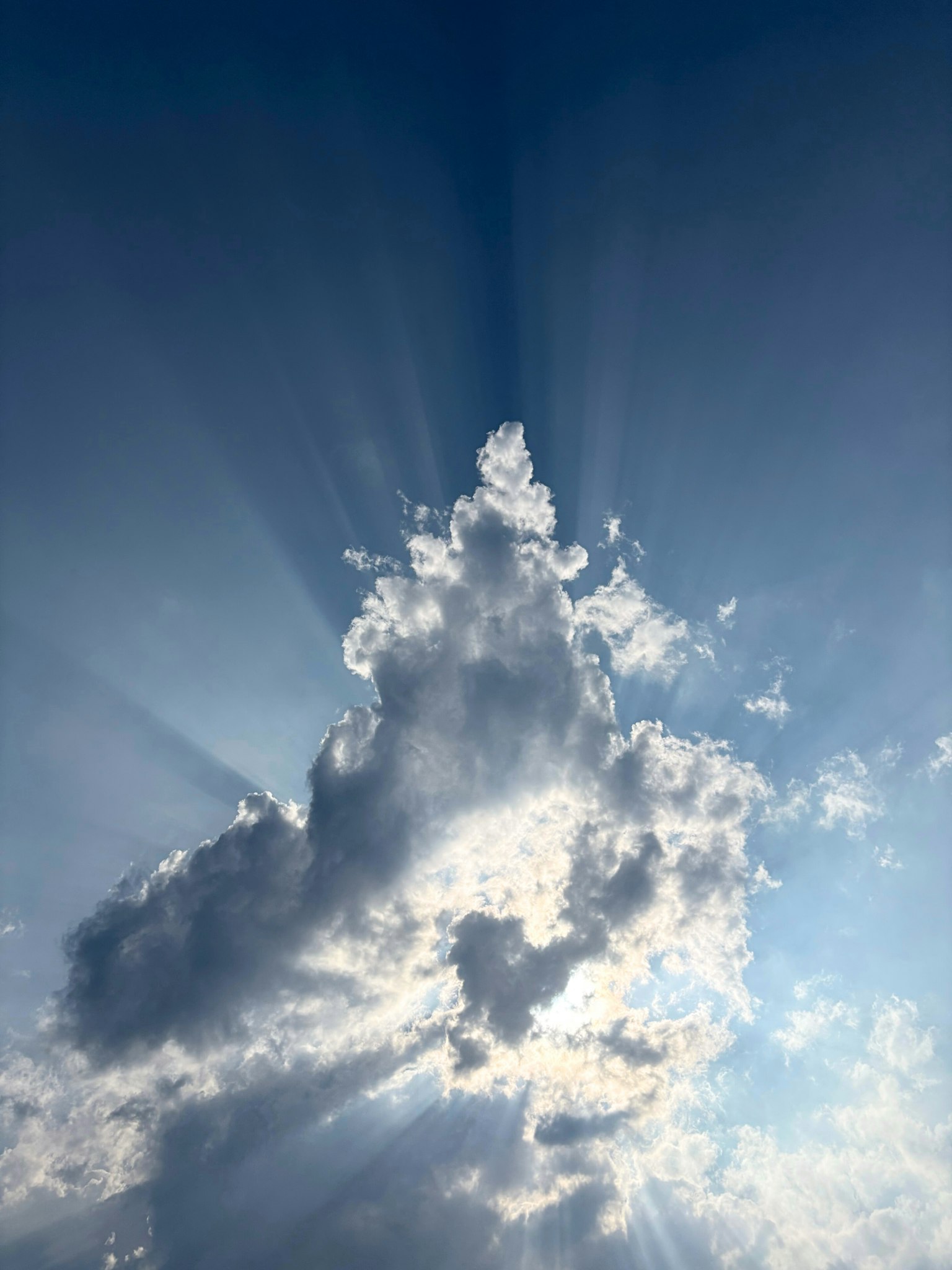 Nuvole illuminate dalla luce del sole con raggi in un cielo blu