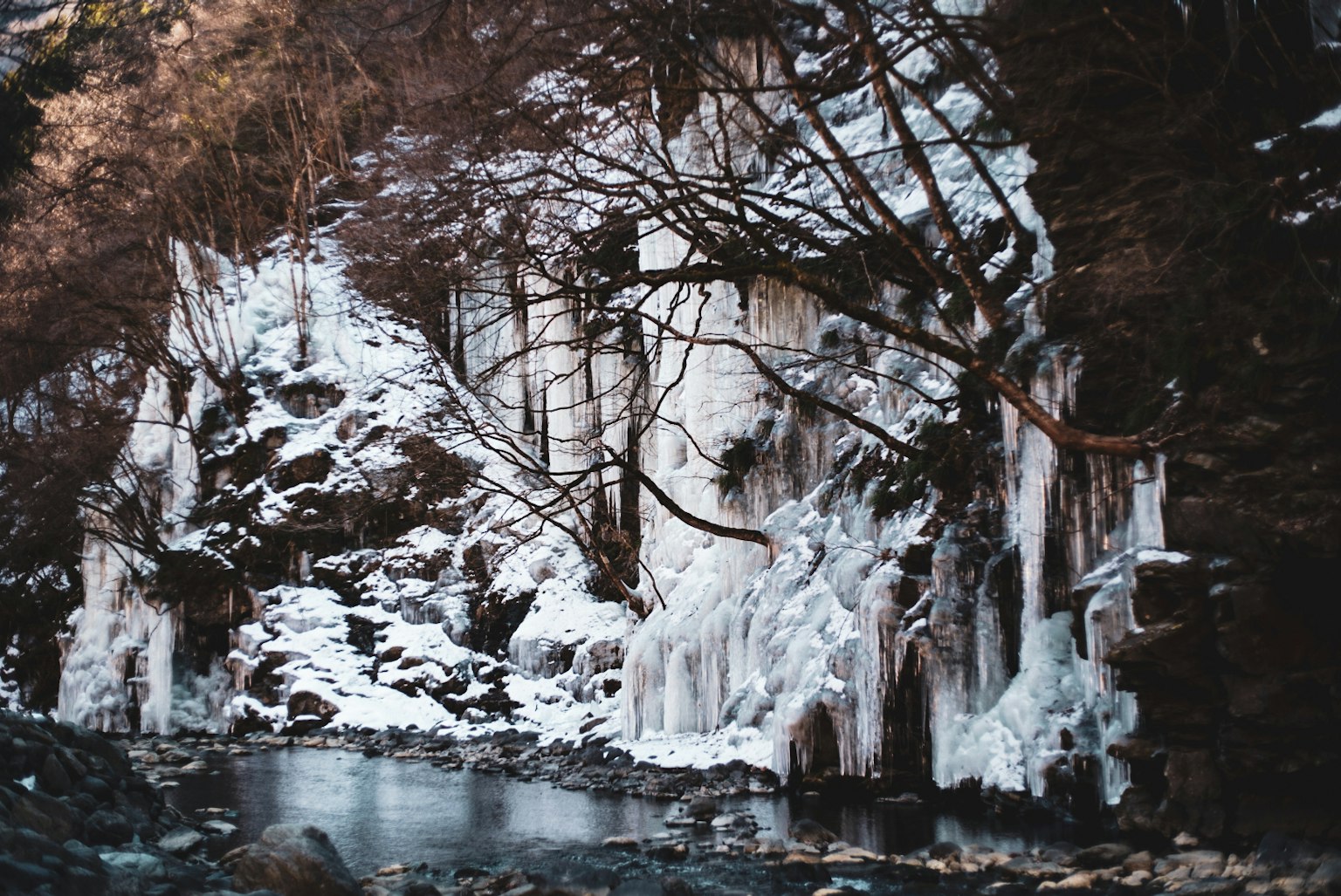 寧靜的河邊景色，雪覆蓋的岩壁和冰的形成