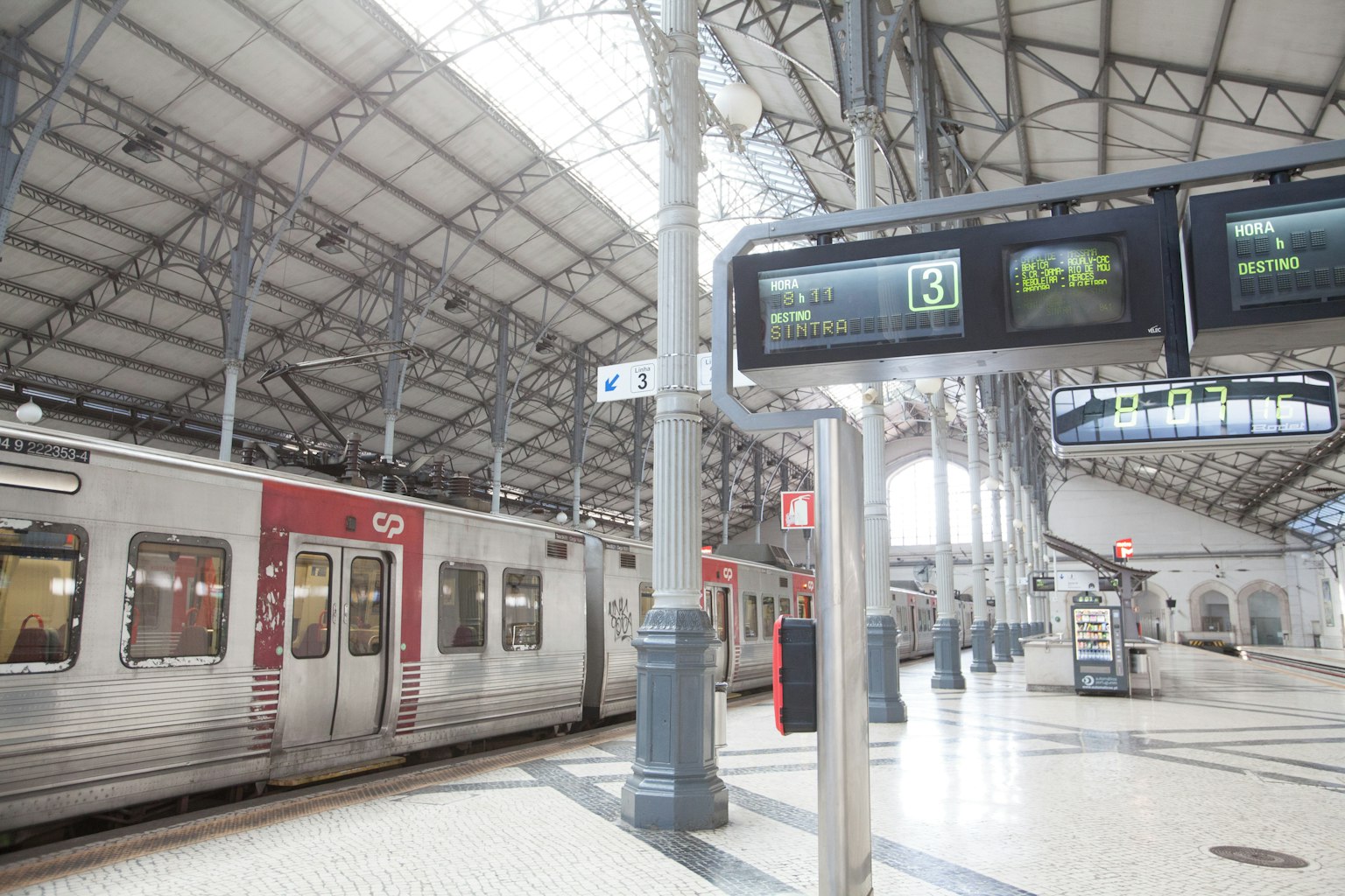 ภายในสถานีรถไฟที่มีแสงสว่างพร้อมรถไฟและจอแสดงผลดิจิตอล