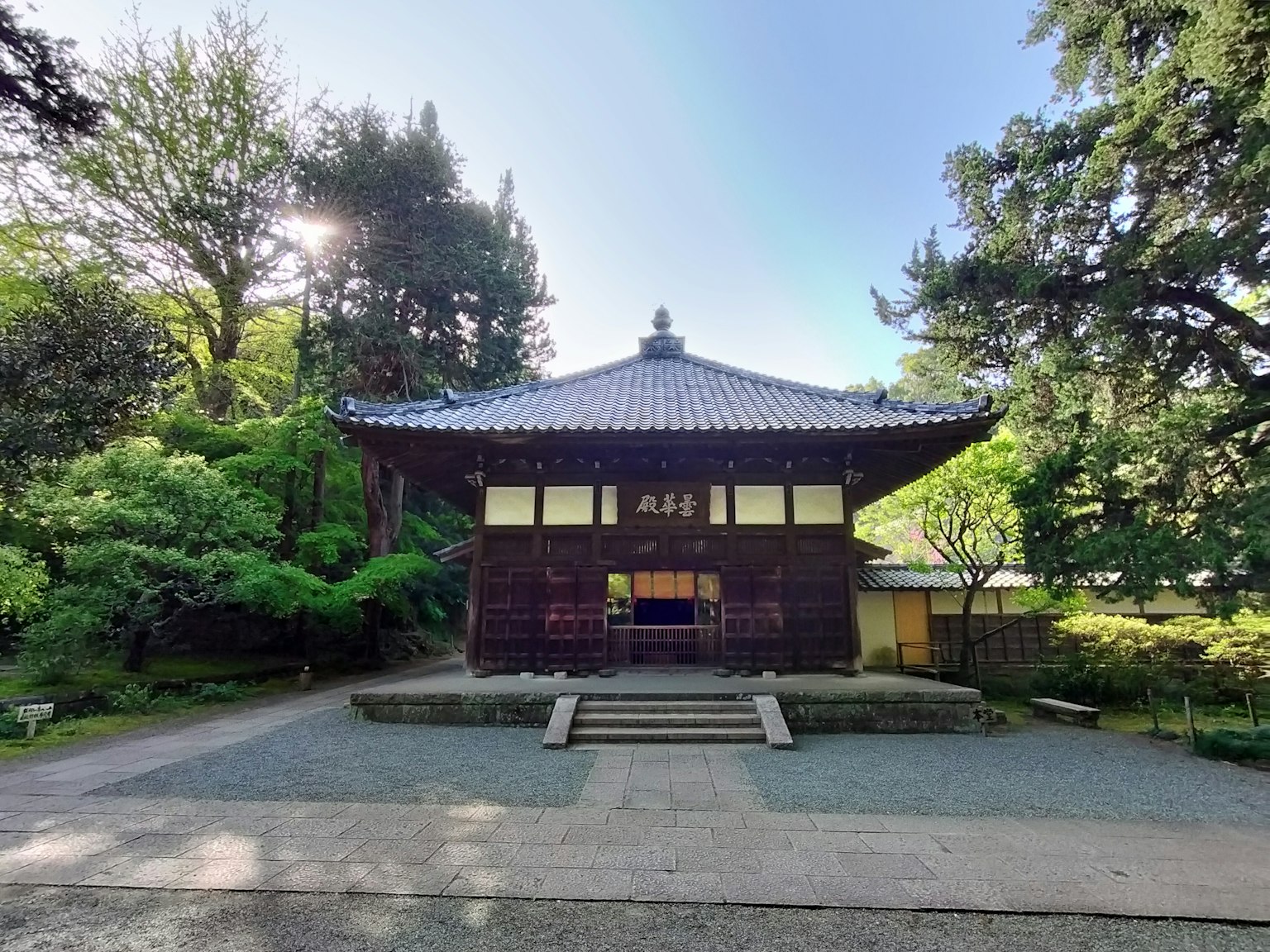 Traditionelles japanisches Tempelgebäude in einem ruhigen Garten, umgeben von üppigem Grün