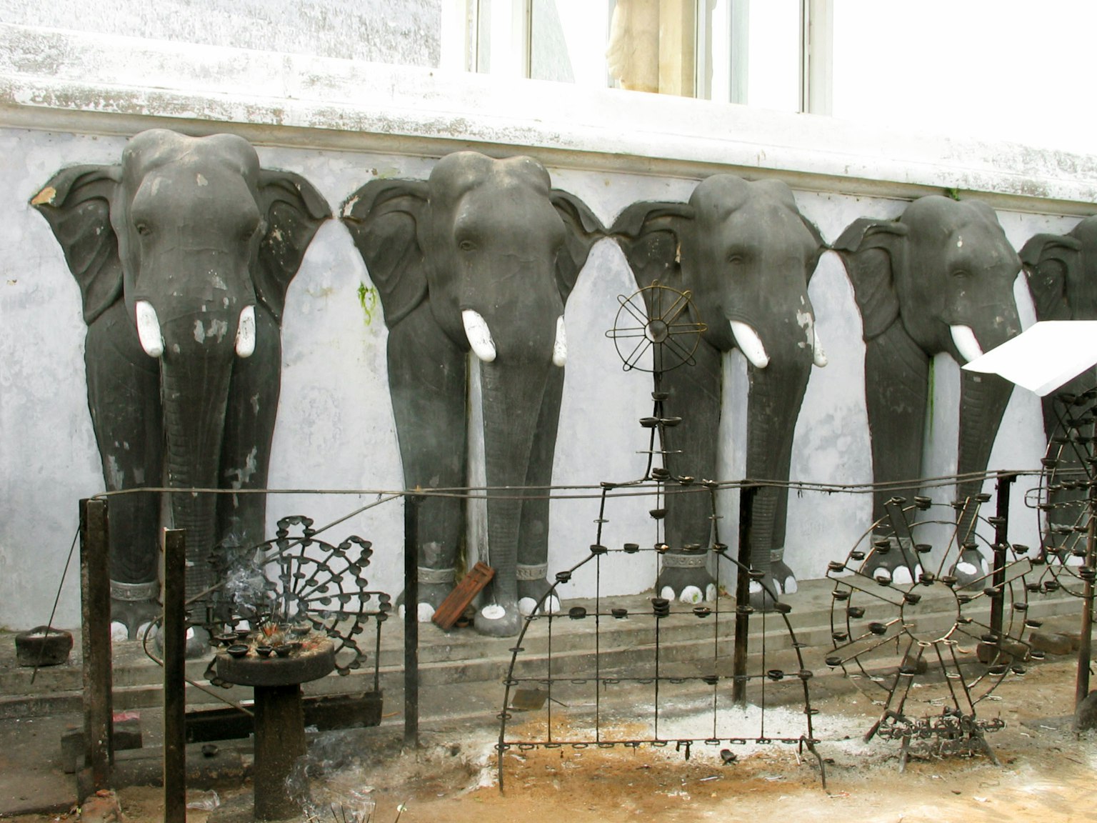 Quatre sculptures d'éléphants noirs alignées sur un mur