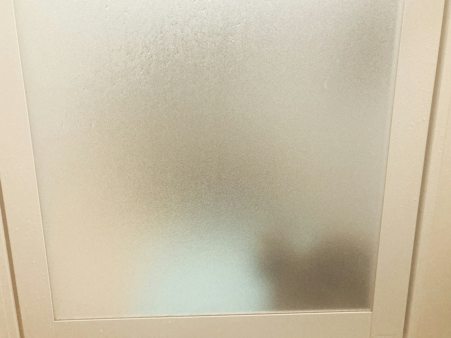 불투명 유리문 뒤에 흐릿한 모습이 보인다