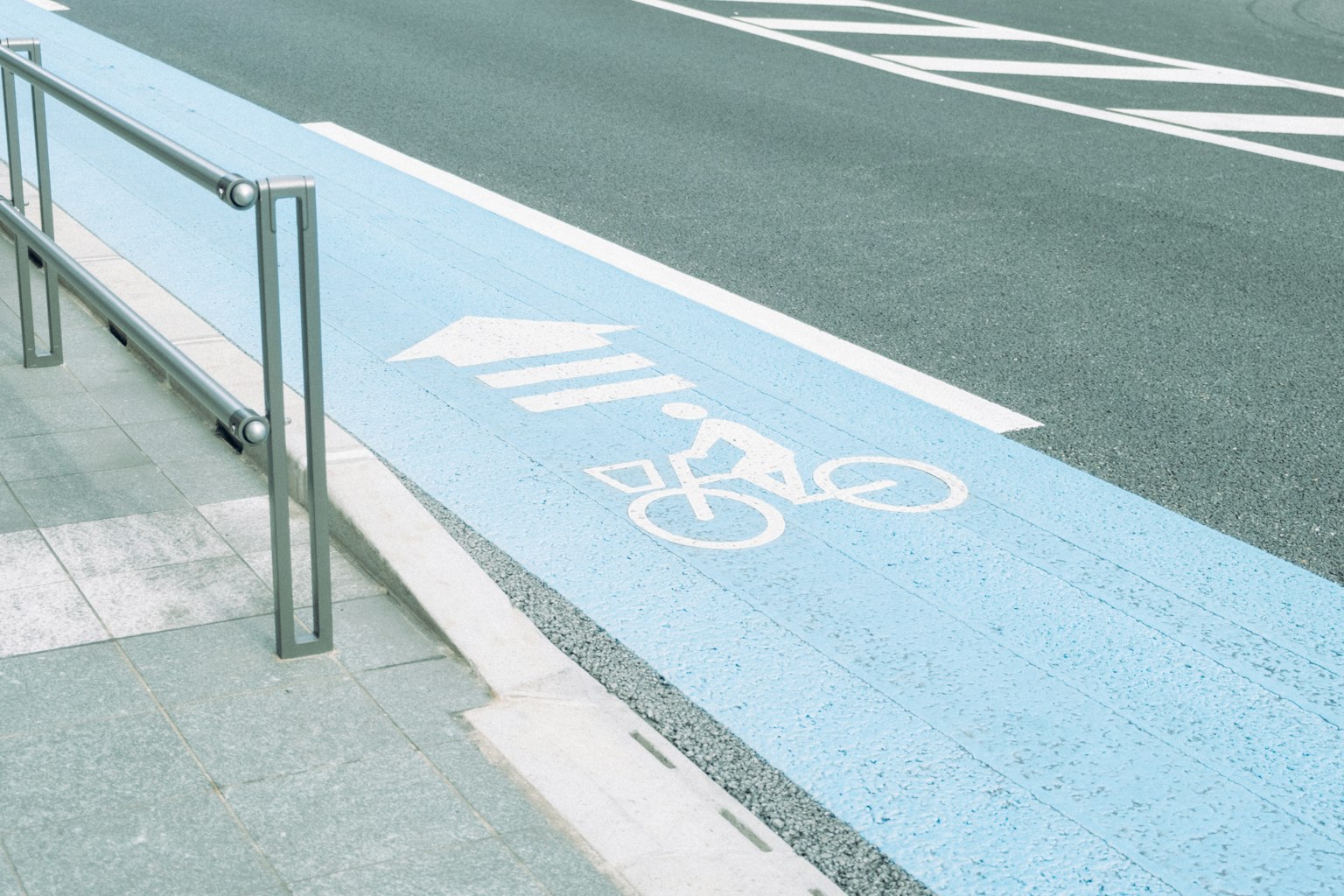 Voie cyclable bleue avec un symbole de bicyclette peint sur la route